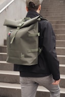 A man walking up some stairs with a backpack on his back