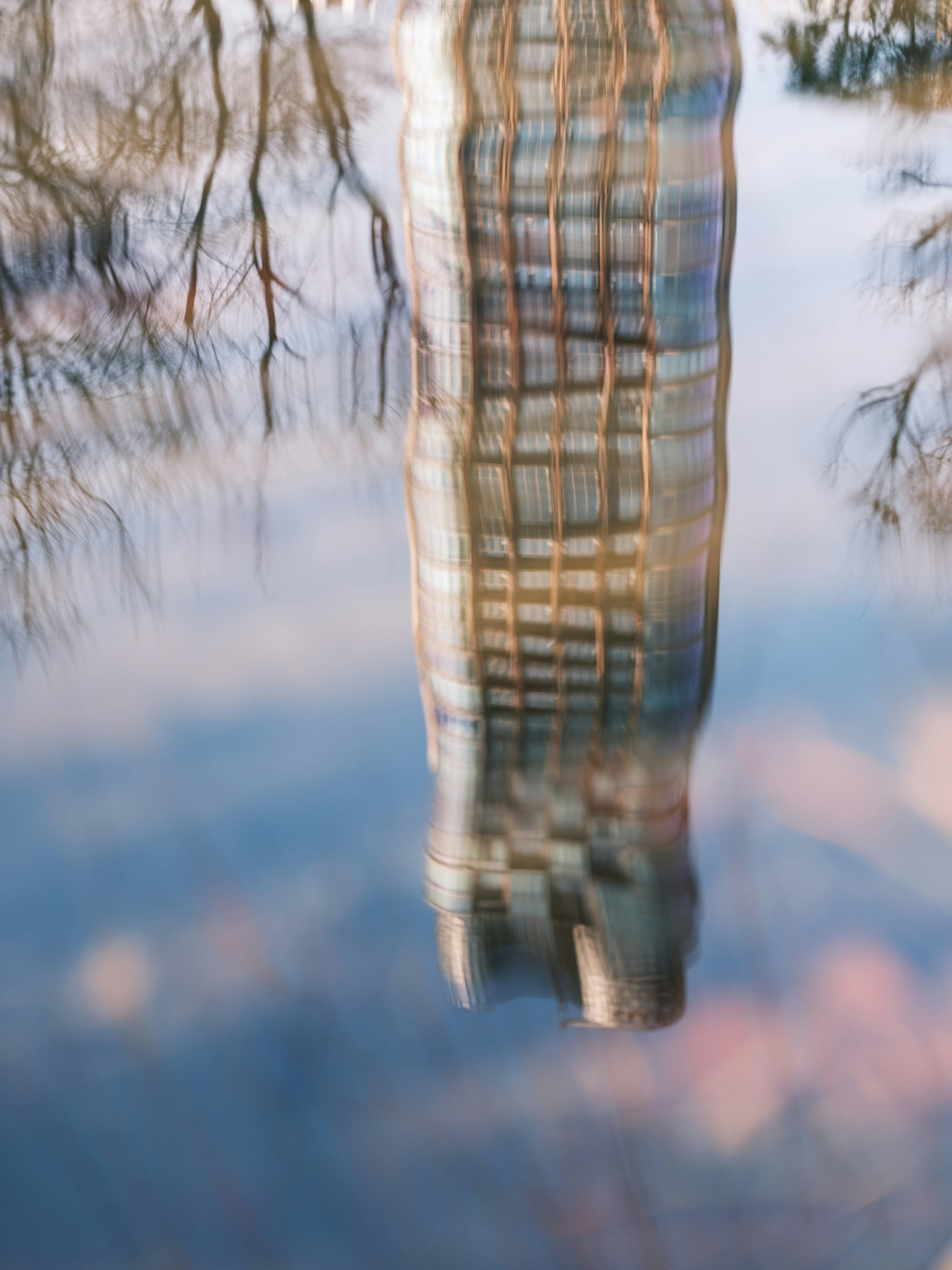 A reflection of a building in a body of water