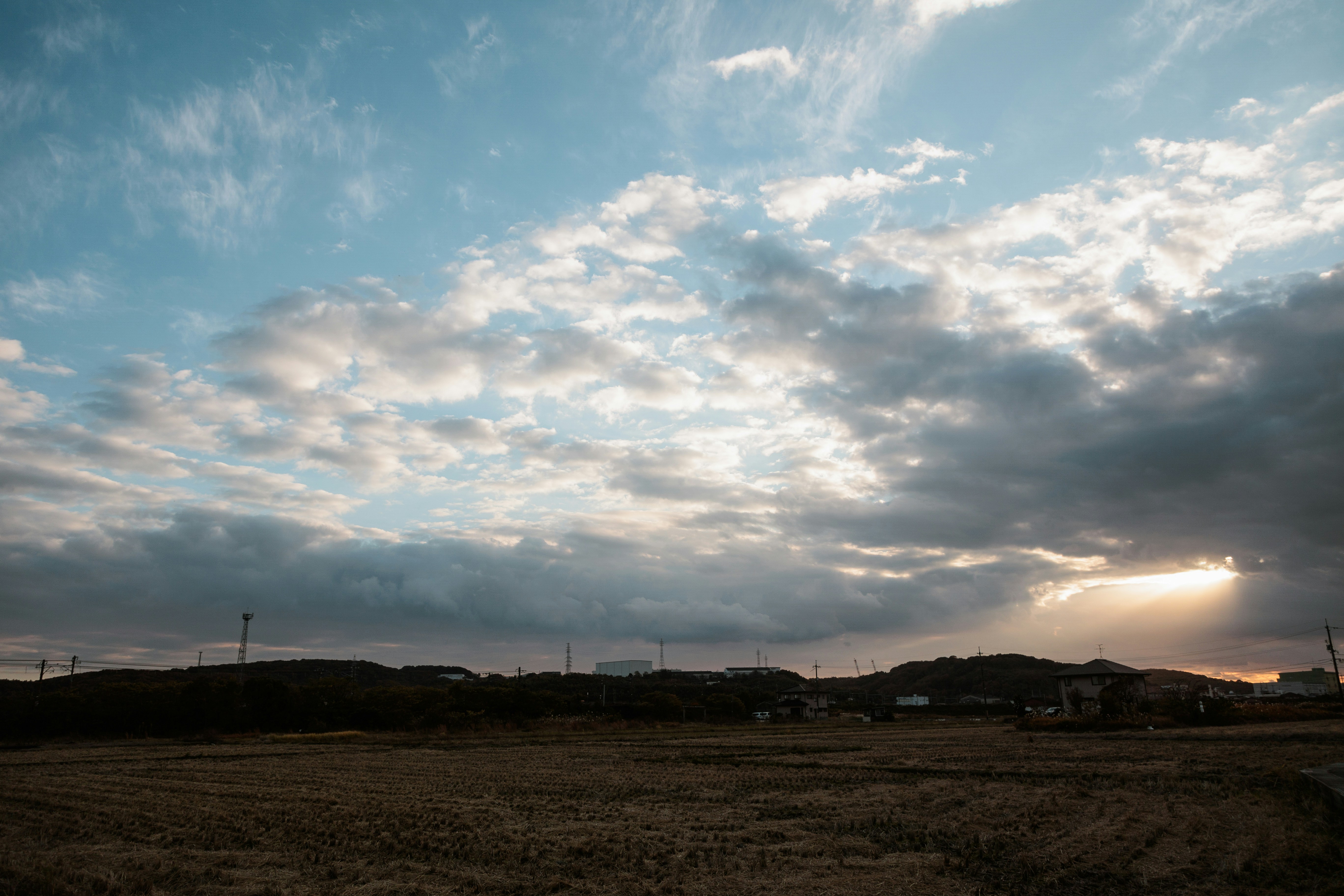 A field with a sky filled with clouds