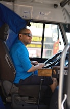 A man sitting in the driver's seat of a bus
