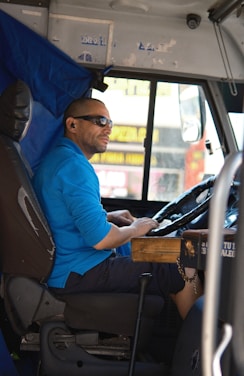 A man sitting in the driver's seat of a bus