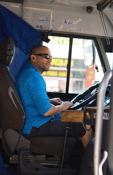 A man sitting in the driver's seat of a bus