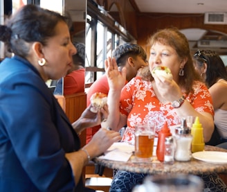 A group of women sitting at a table eating food
