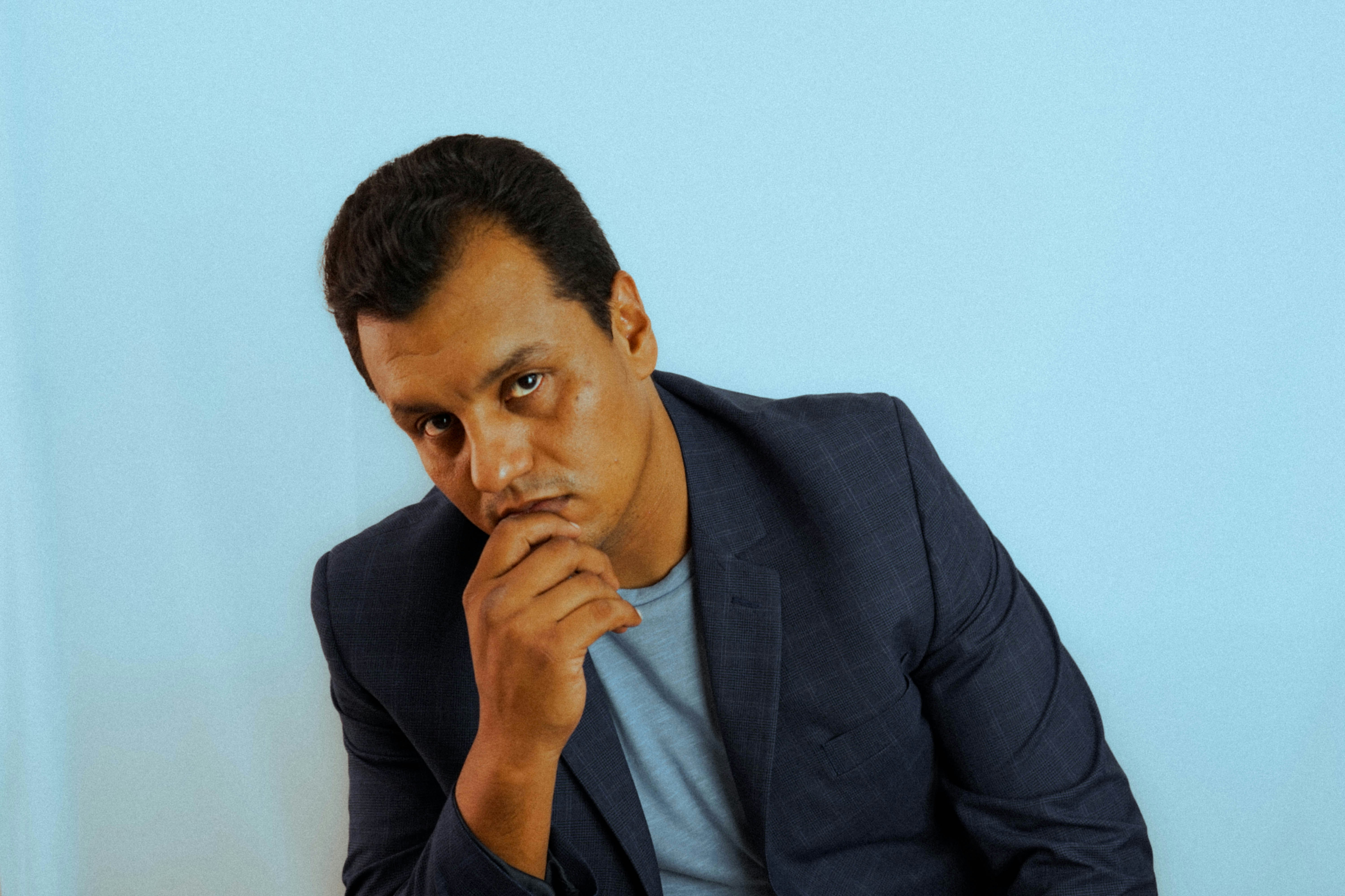 A man sitting at a desk with his hand on his chin