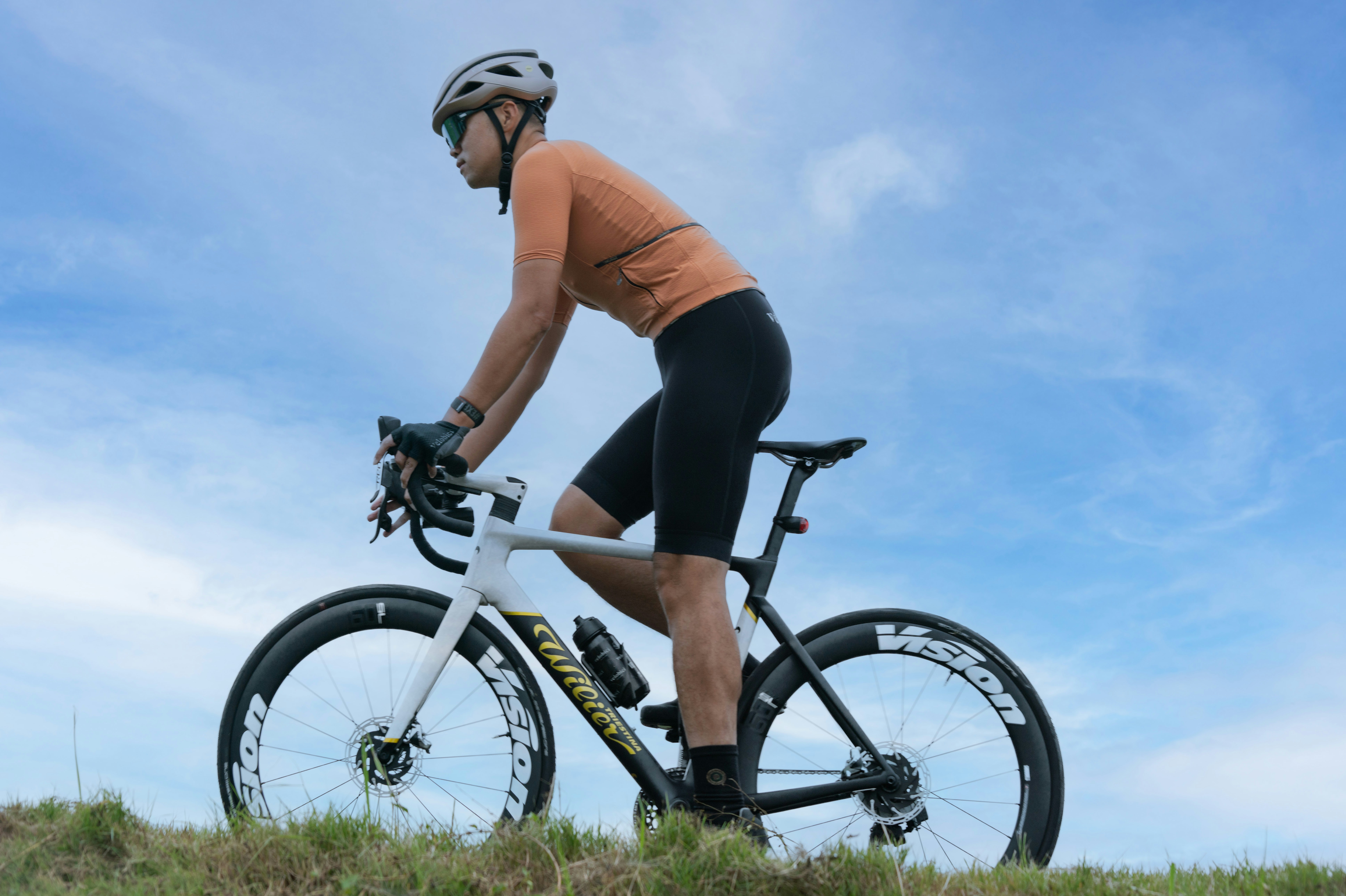 A man riding a bike on top of a lush green field
