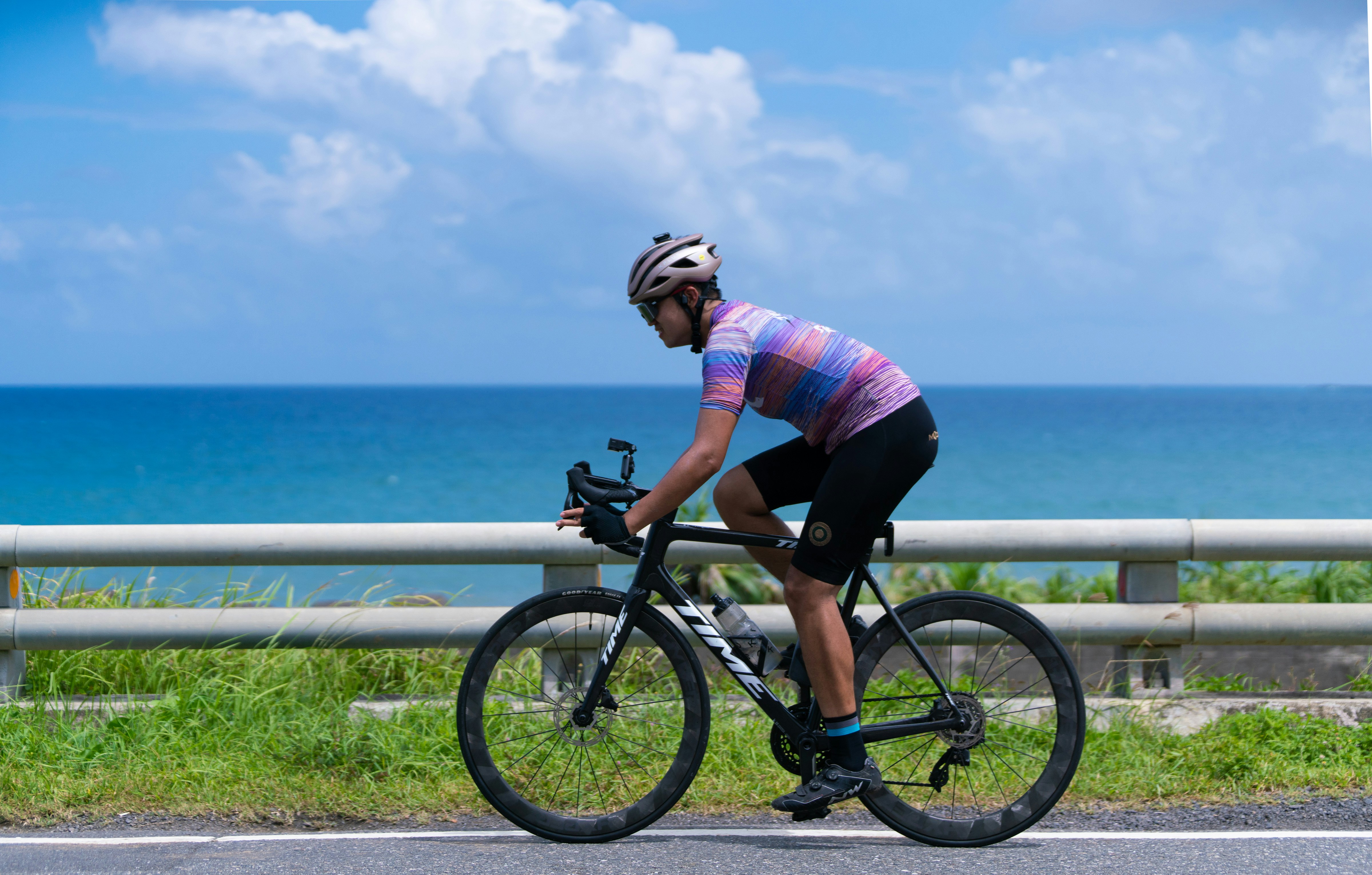 A man riding a bike down a road next to the ocean