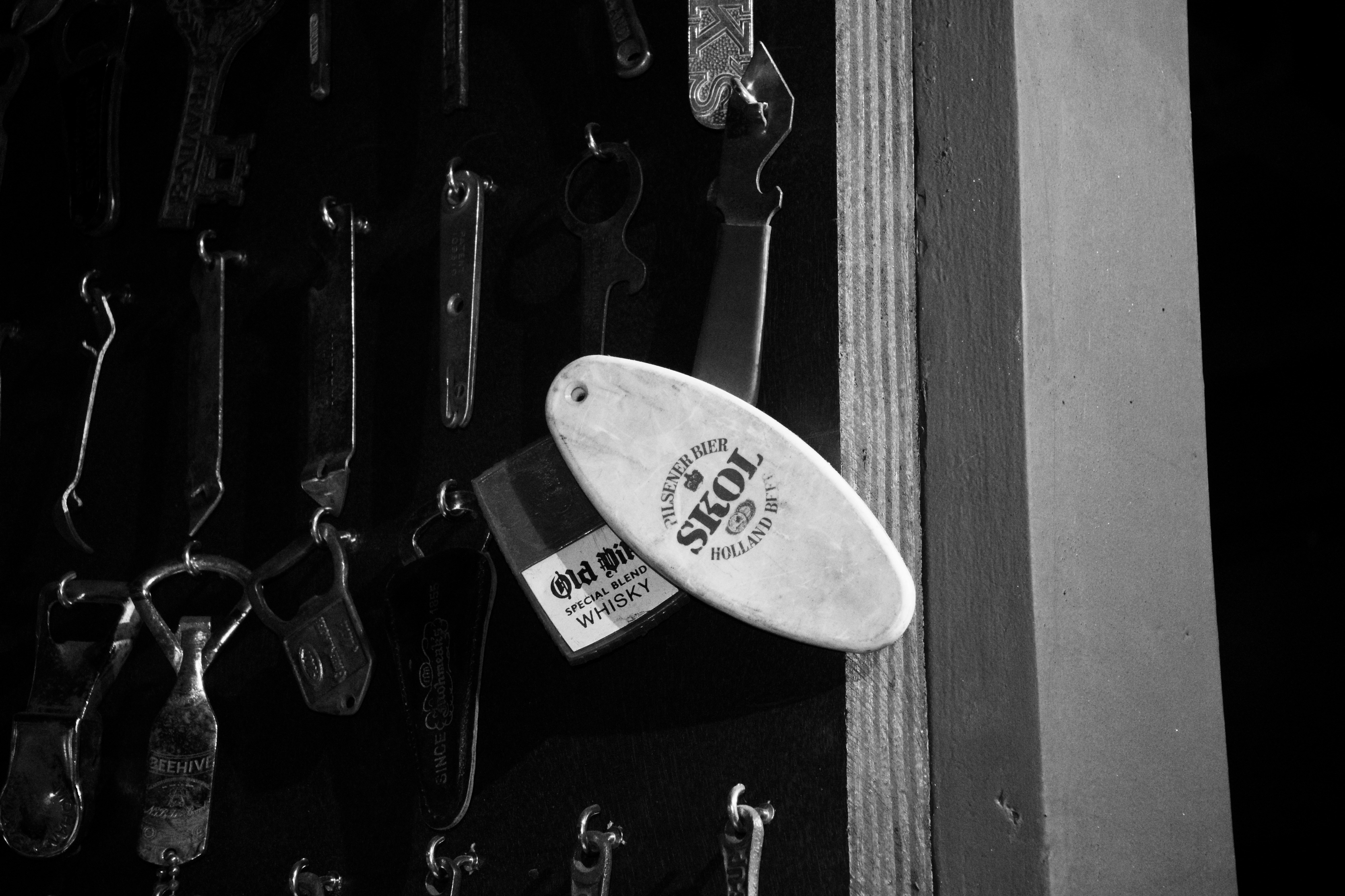 A surfboard is hanging on a wall of keys