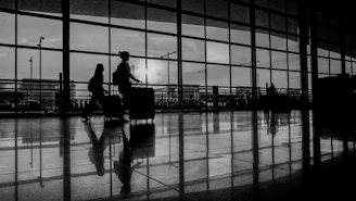 A couple of people that are walking with luggage
