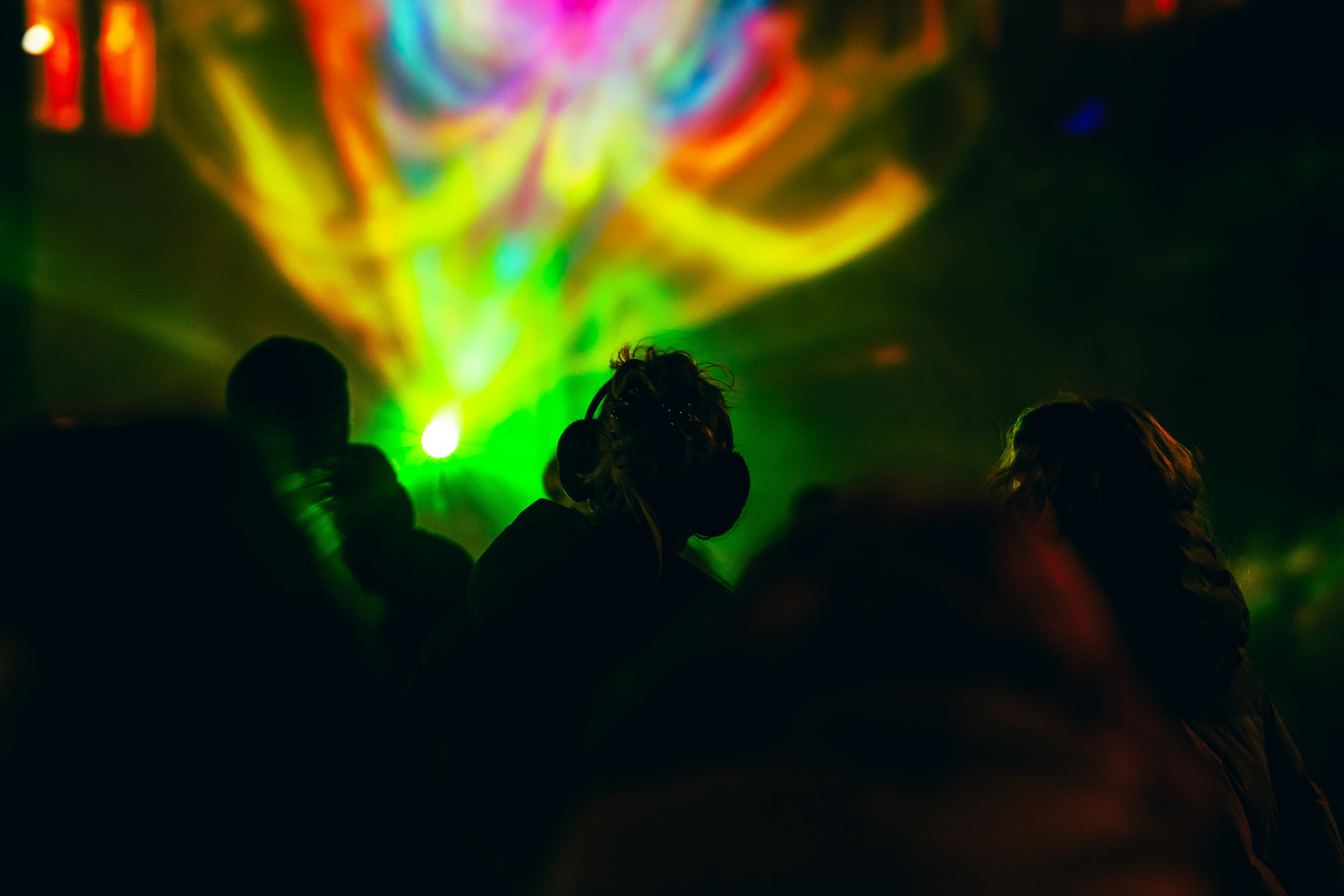 A group of people standing in front of a colorful light