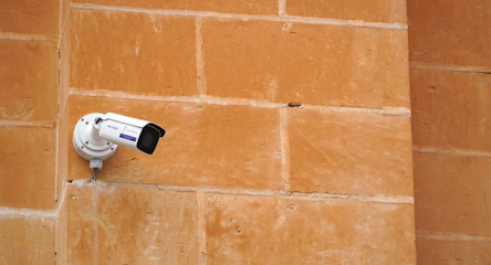 A security camera attached to a brick wall