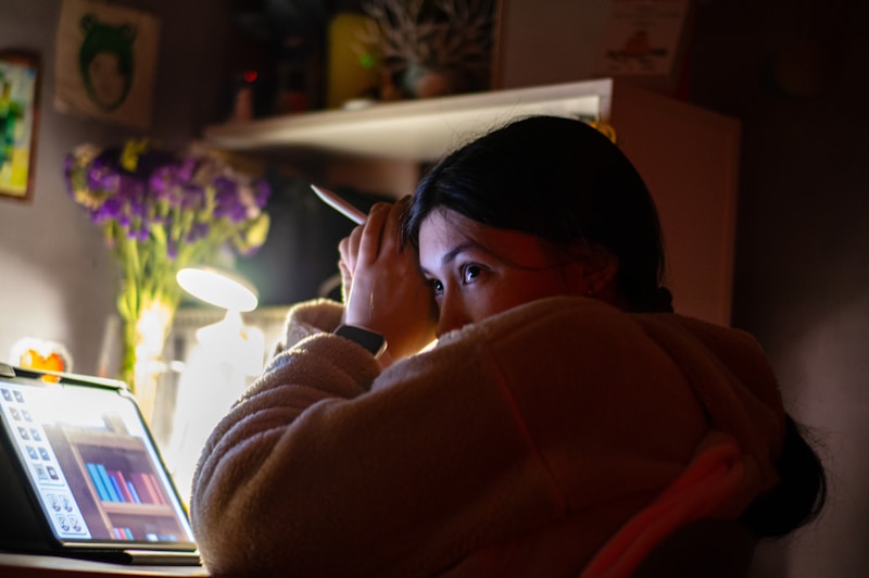 A woman sitting in front of a laptop computer