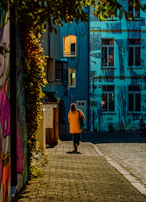 A man walking down a street next to tall buildings