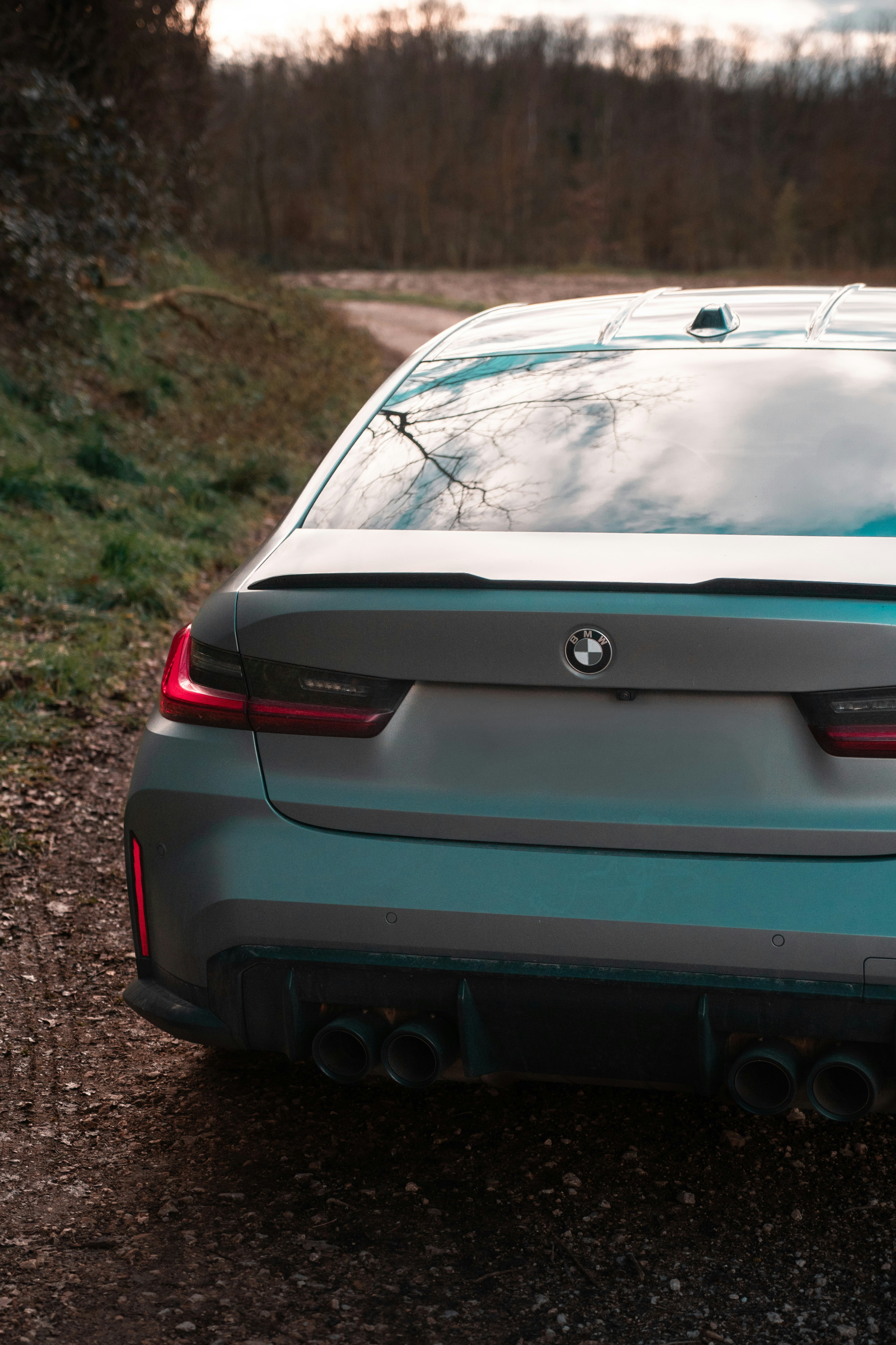 A car parked on the side of a dirt road