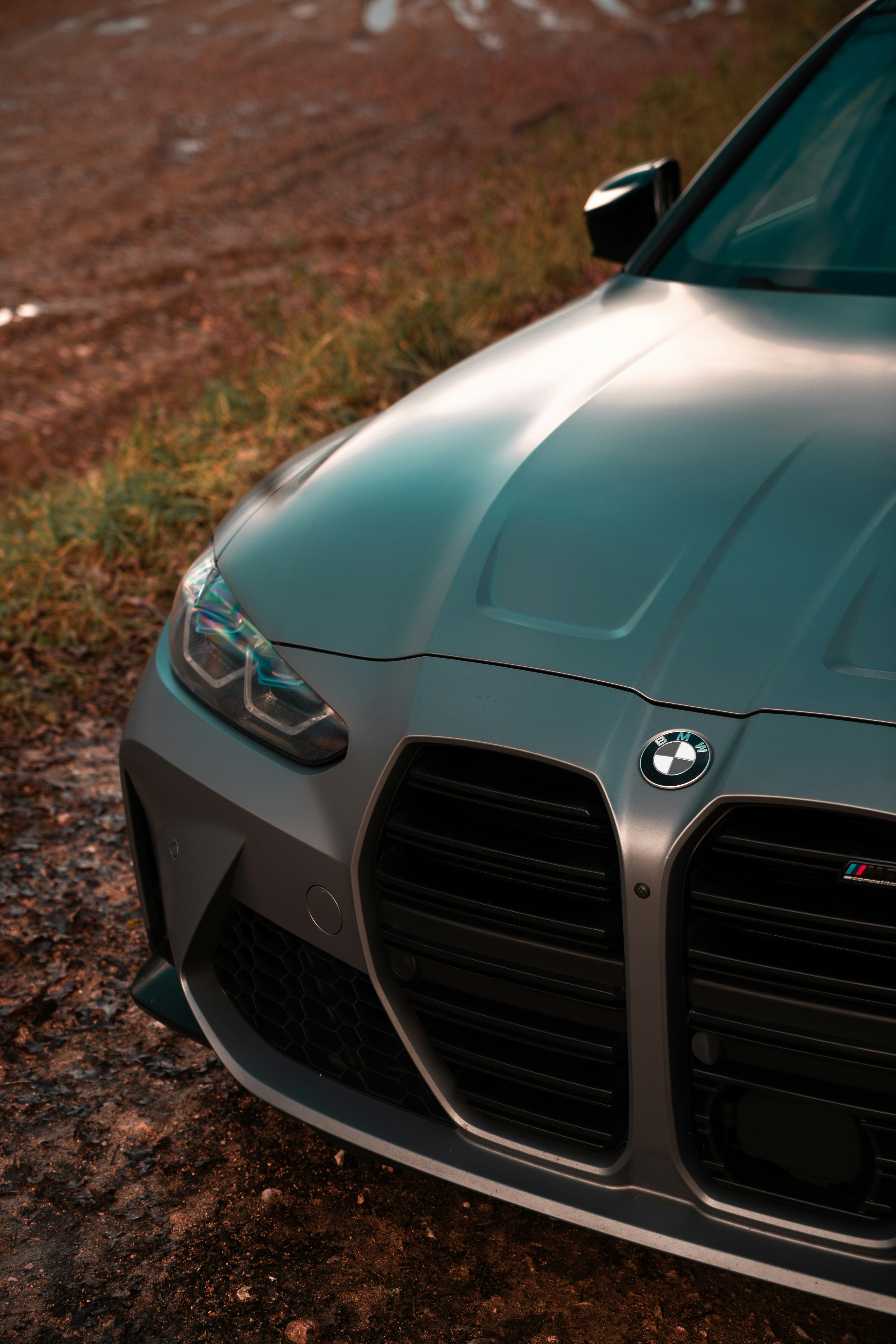A close up of a car parked on a dirt road