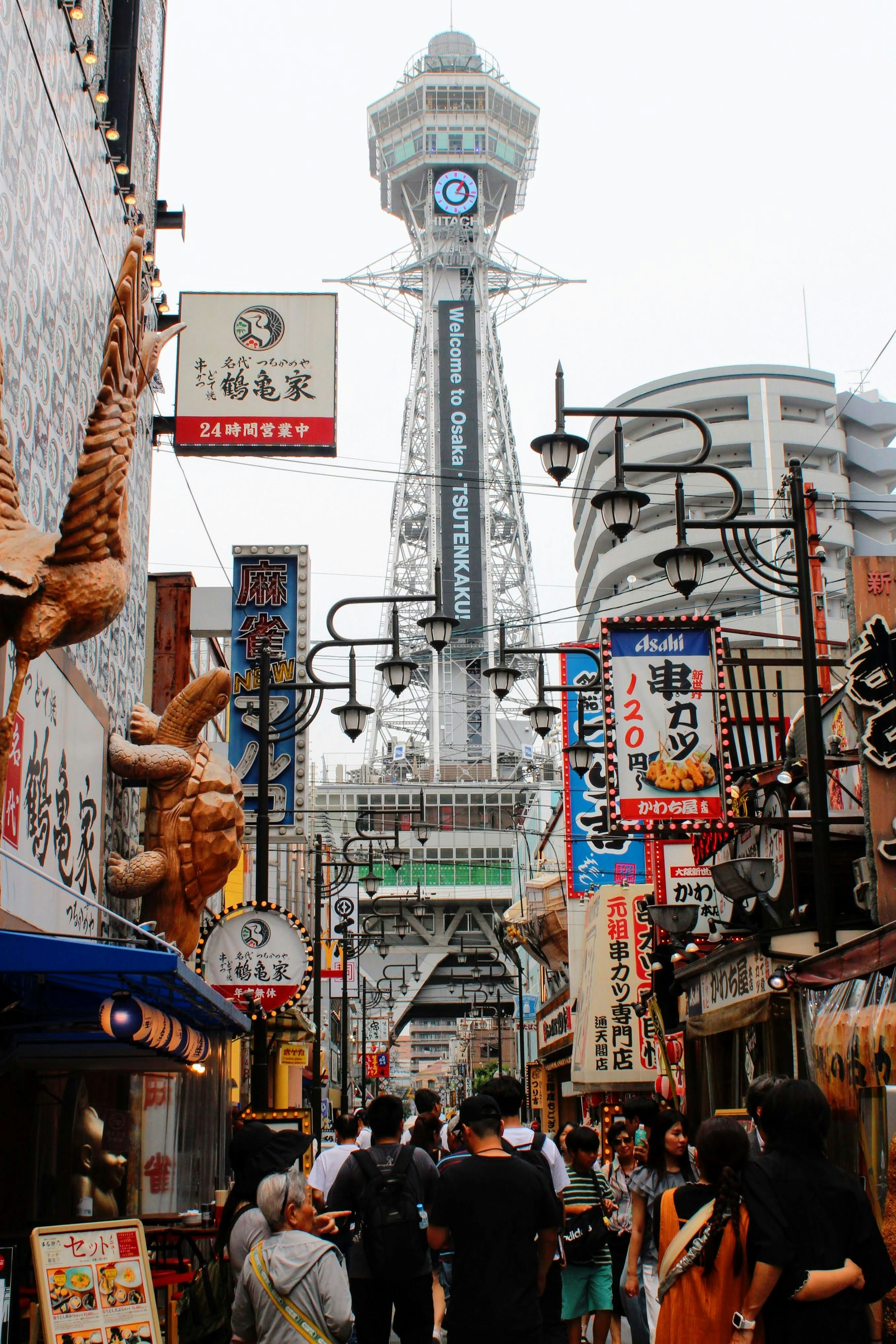 A crowded city street with a tall tower in the background