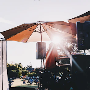 A person sitting under an umbrella in the sun