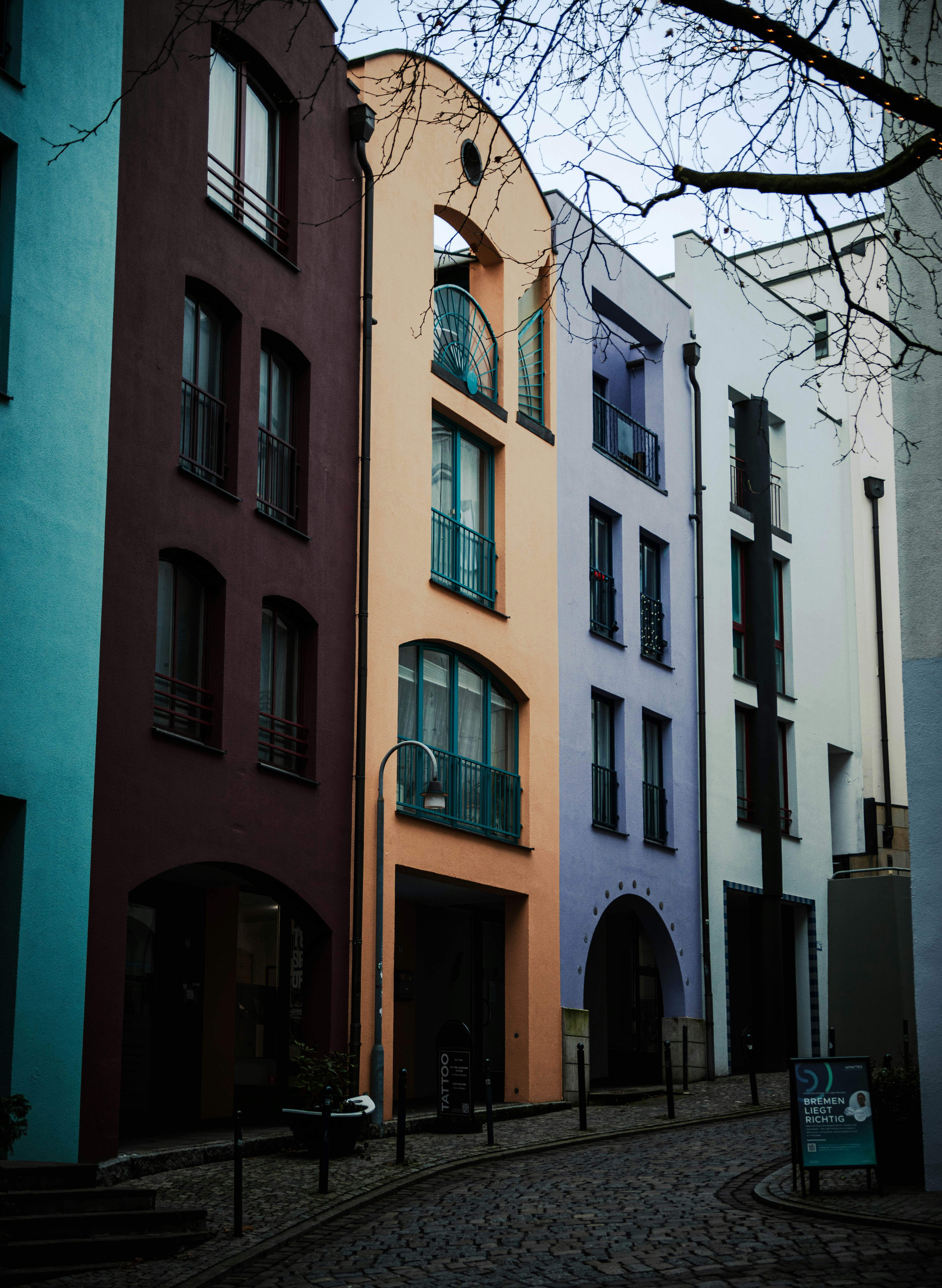 A row of multicolored buildings on a cobblestone street