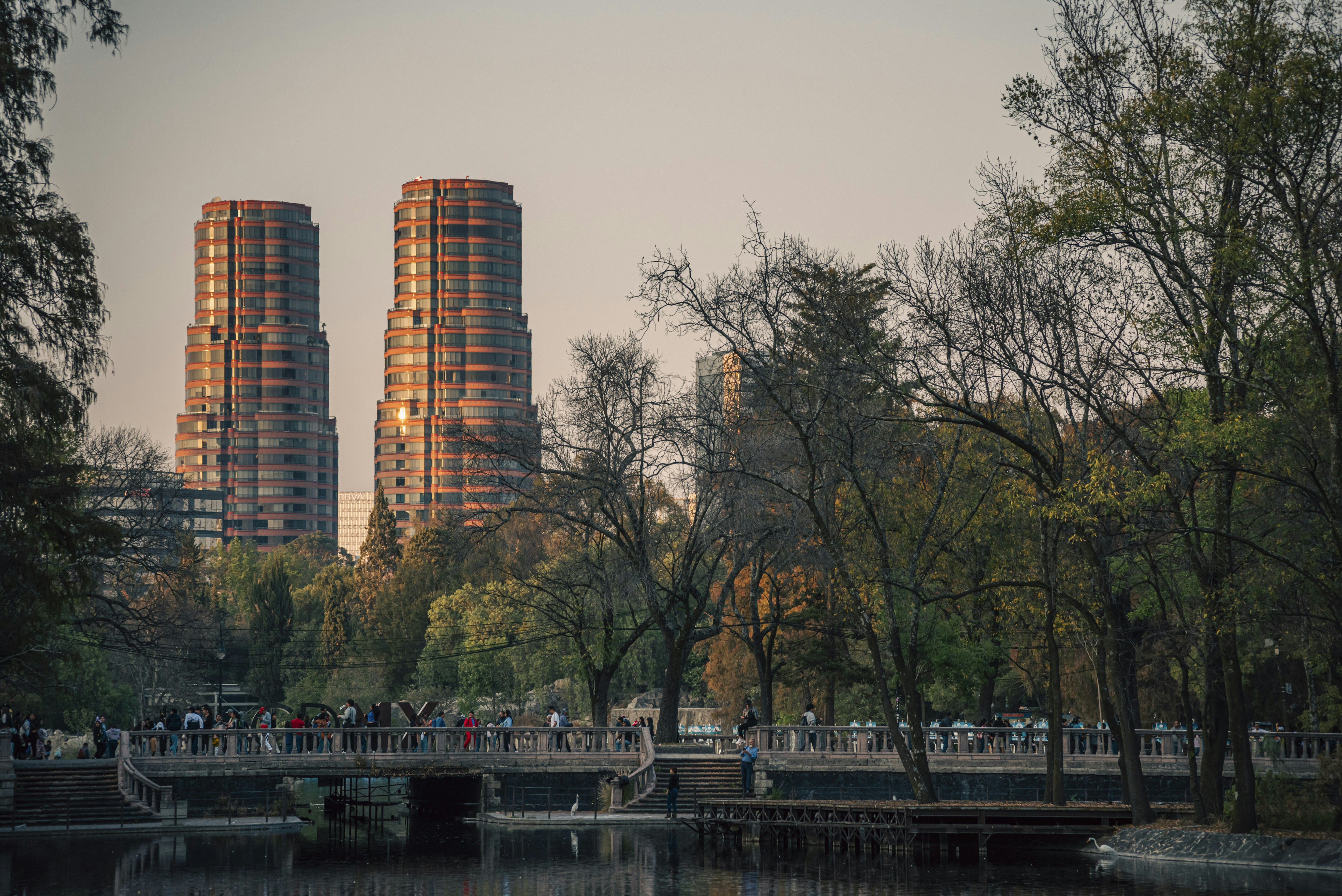 Two tall buildings are in the background of a body of water