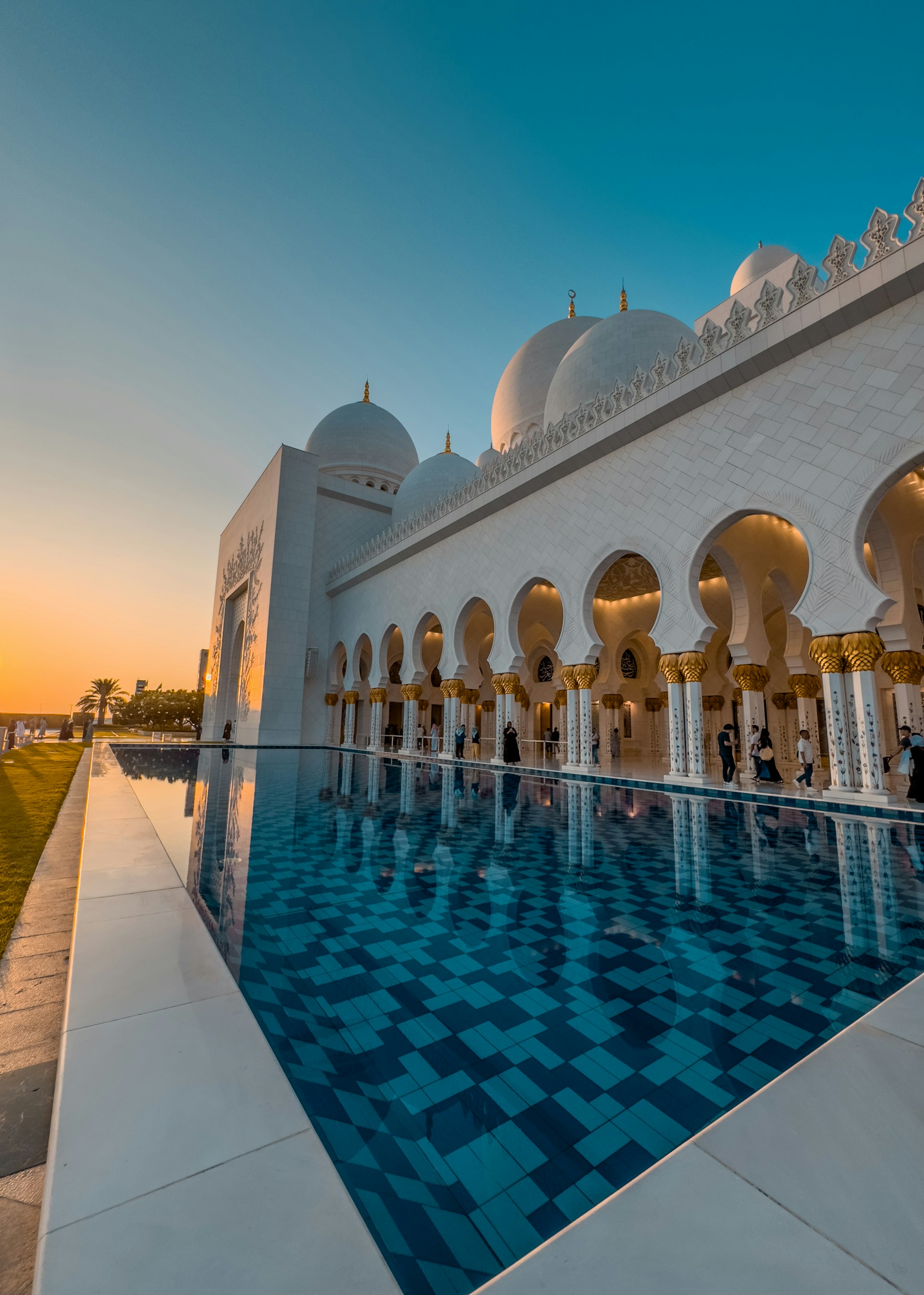 A large white building with a pool in front of it