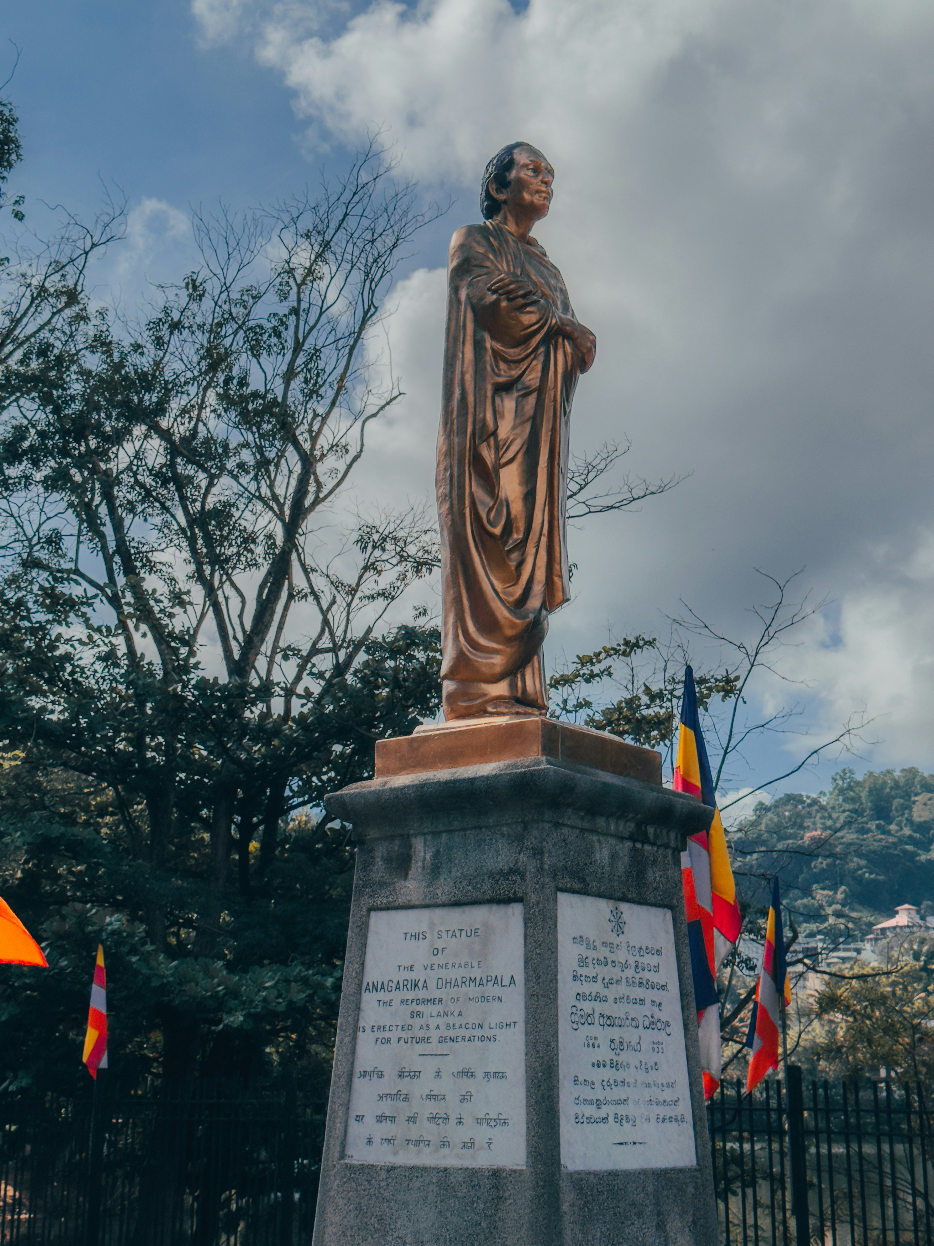 Eine Statue einer Frau, die vor einem Zaun steht