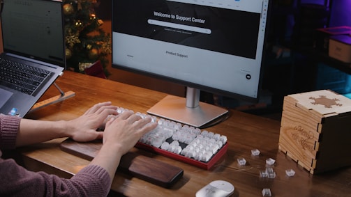 A person sitting at a desk typing on a keyboard