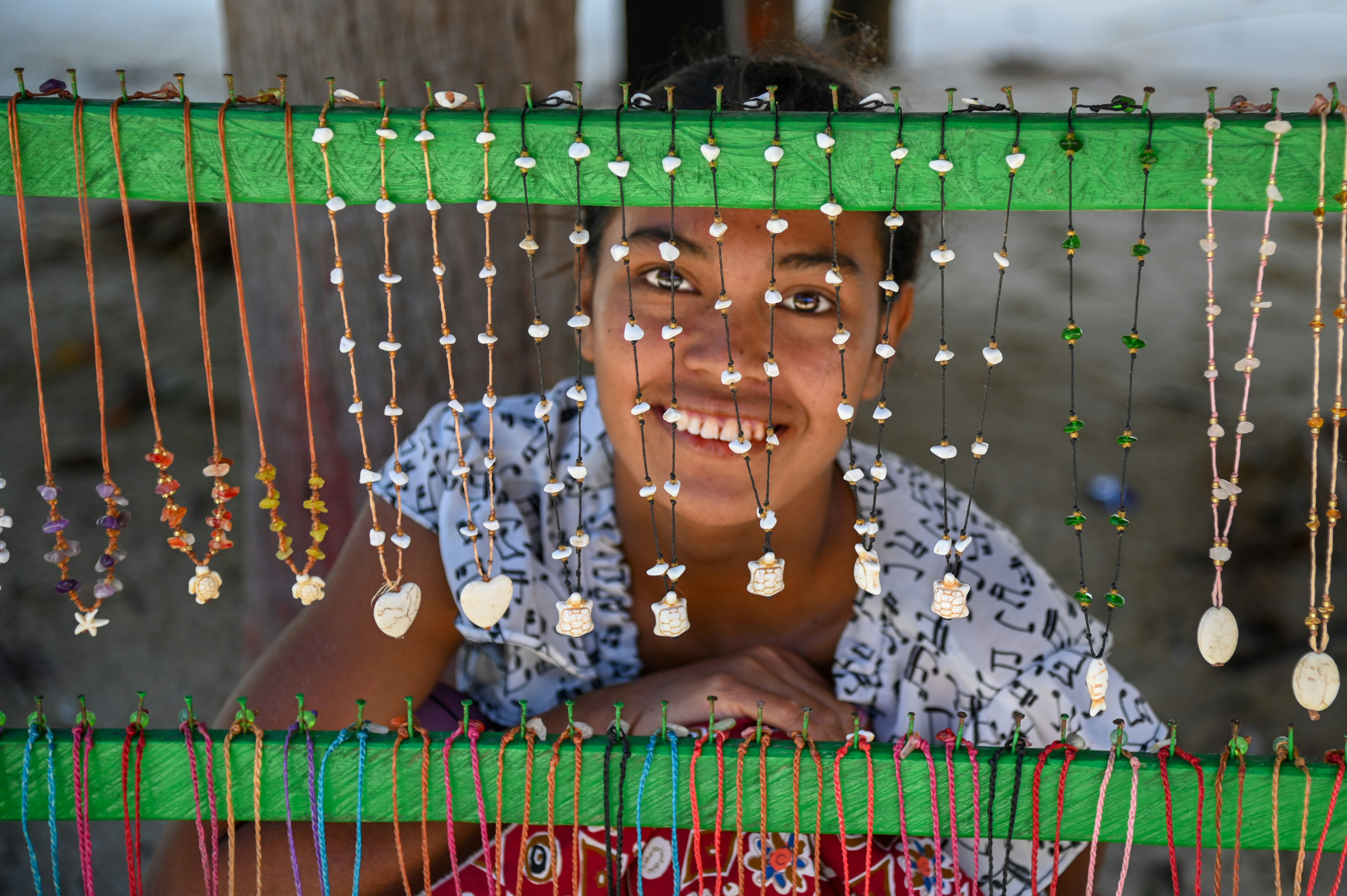 A woman is smiling behind a green screen