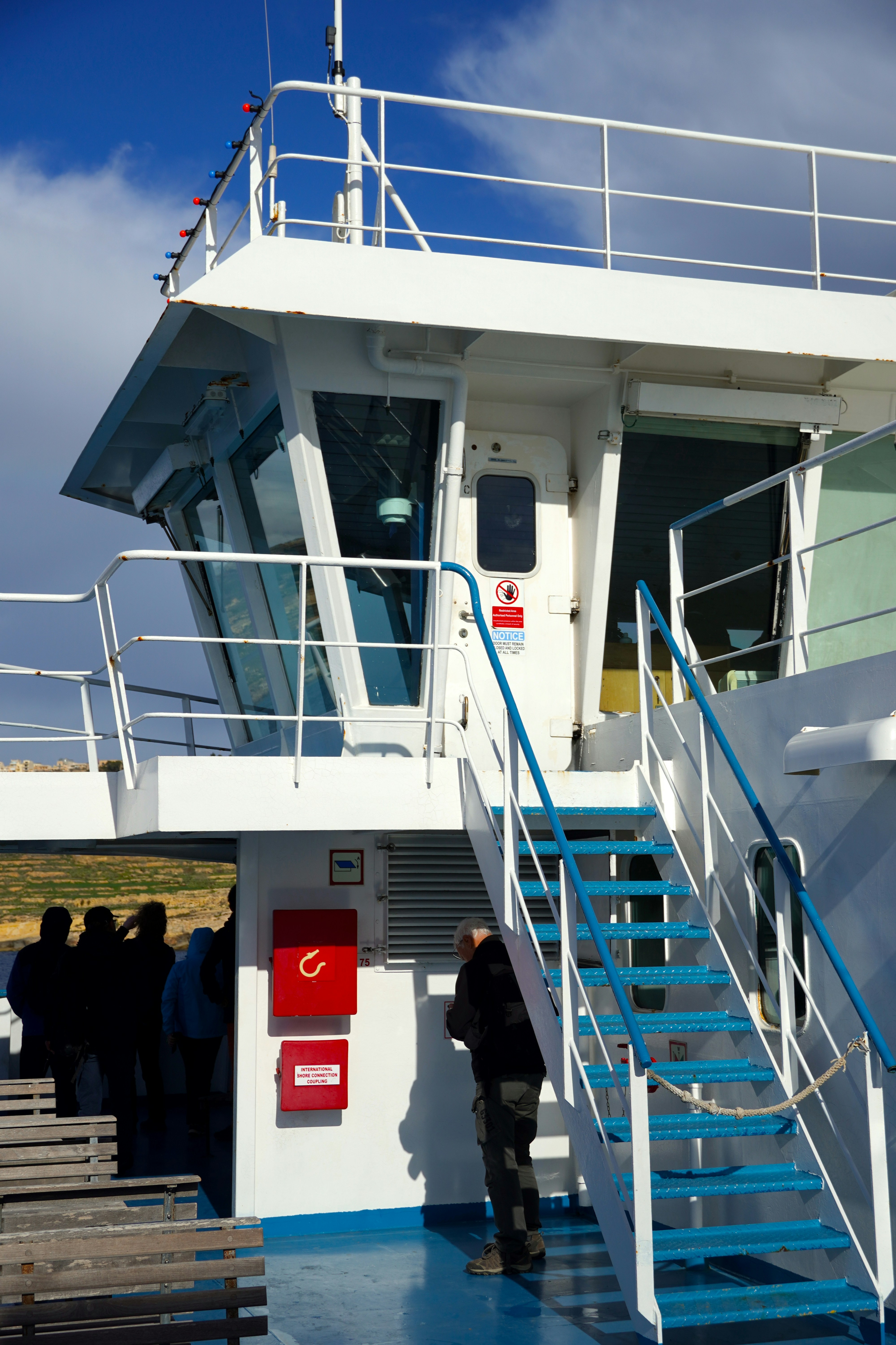 A group of people standing on the deck of a boat