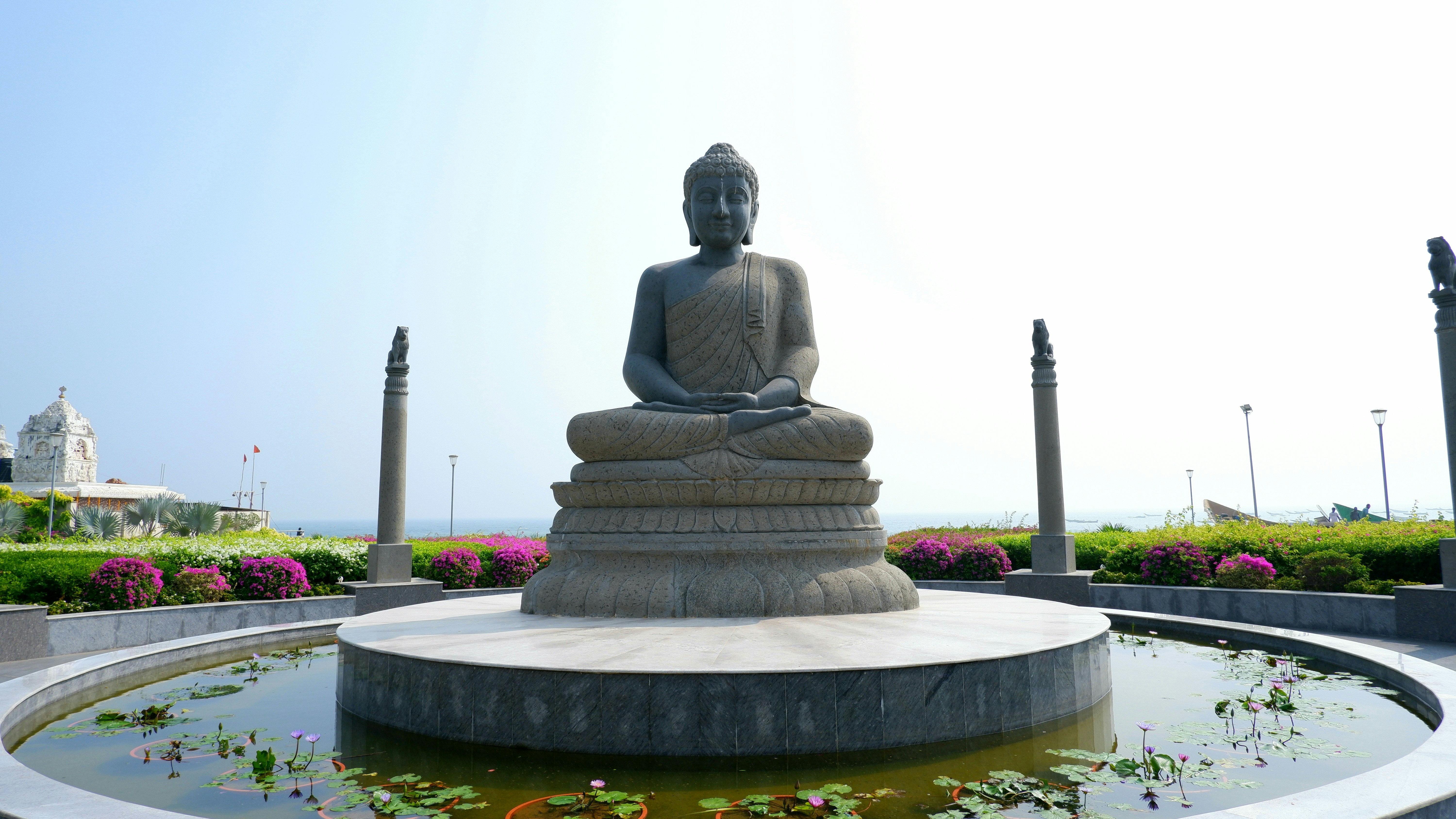 A statue of a buddha sitting on top of a fountain