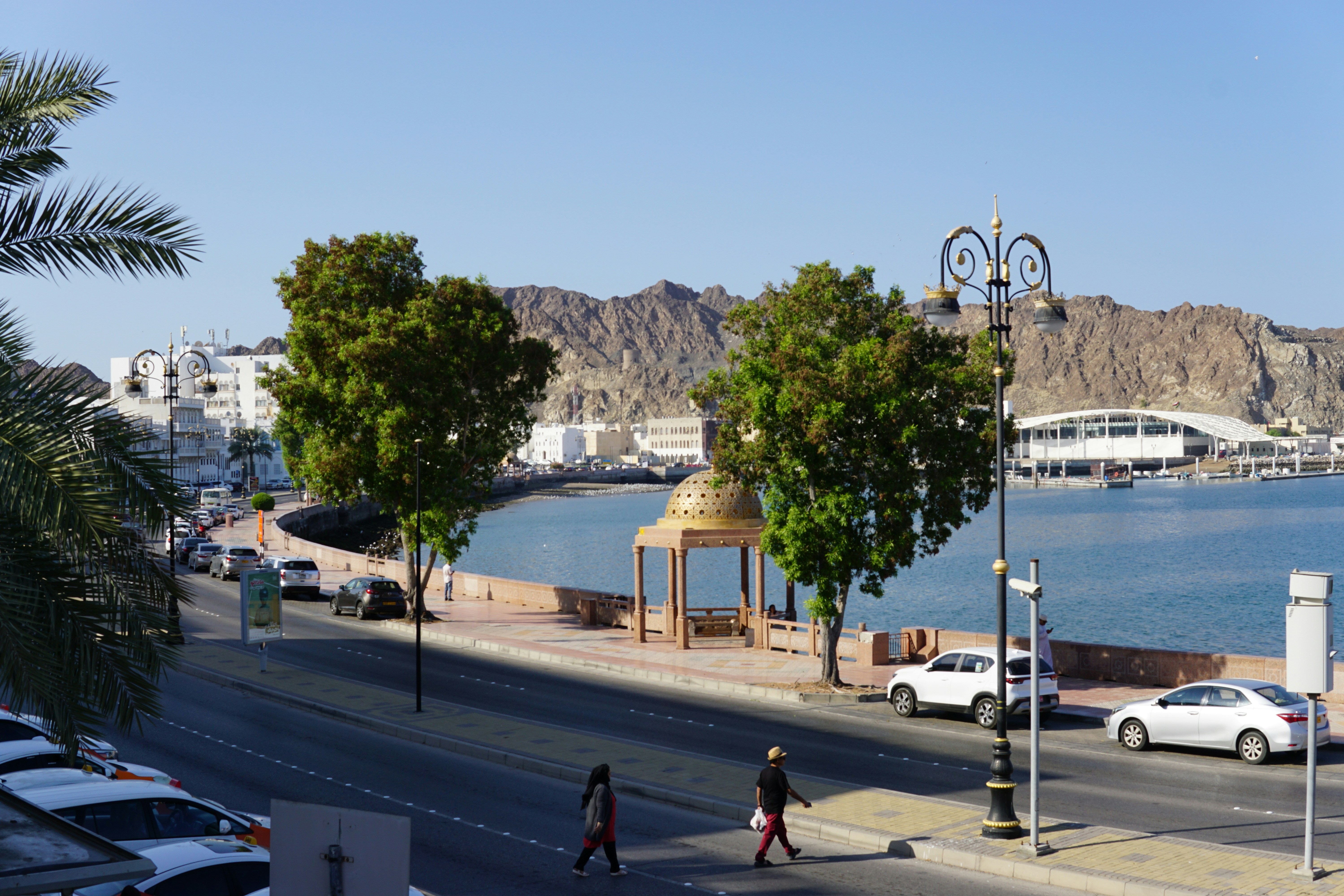 A city street with cars parked on the side of the road