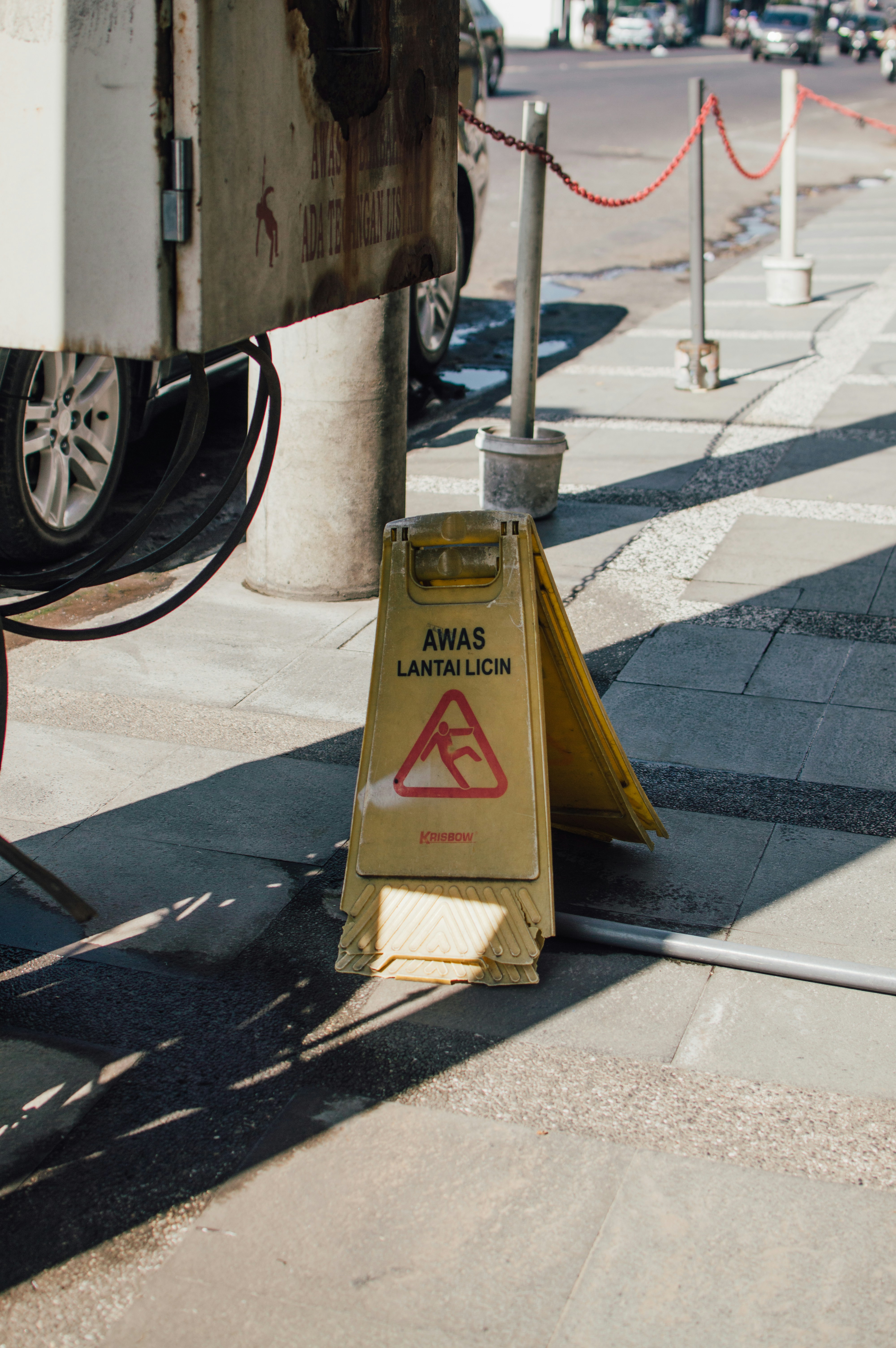 A yellow caution sign sitting on the side of a road