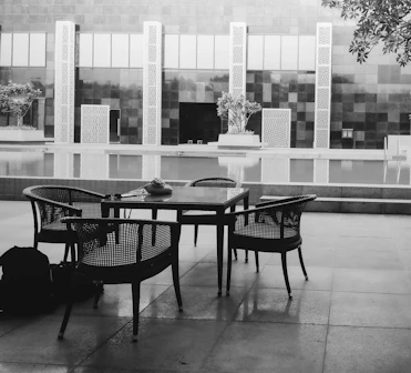 A black and white photo of a table and chairs