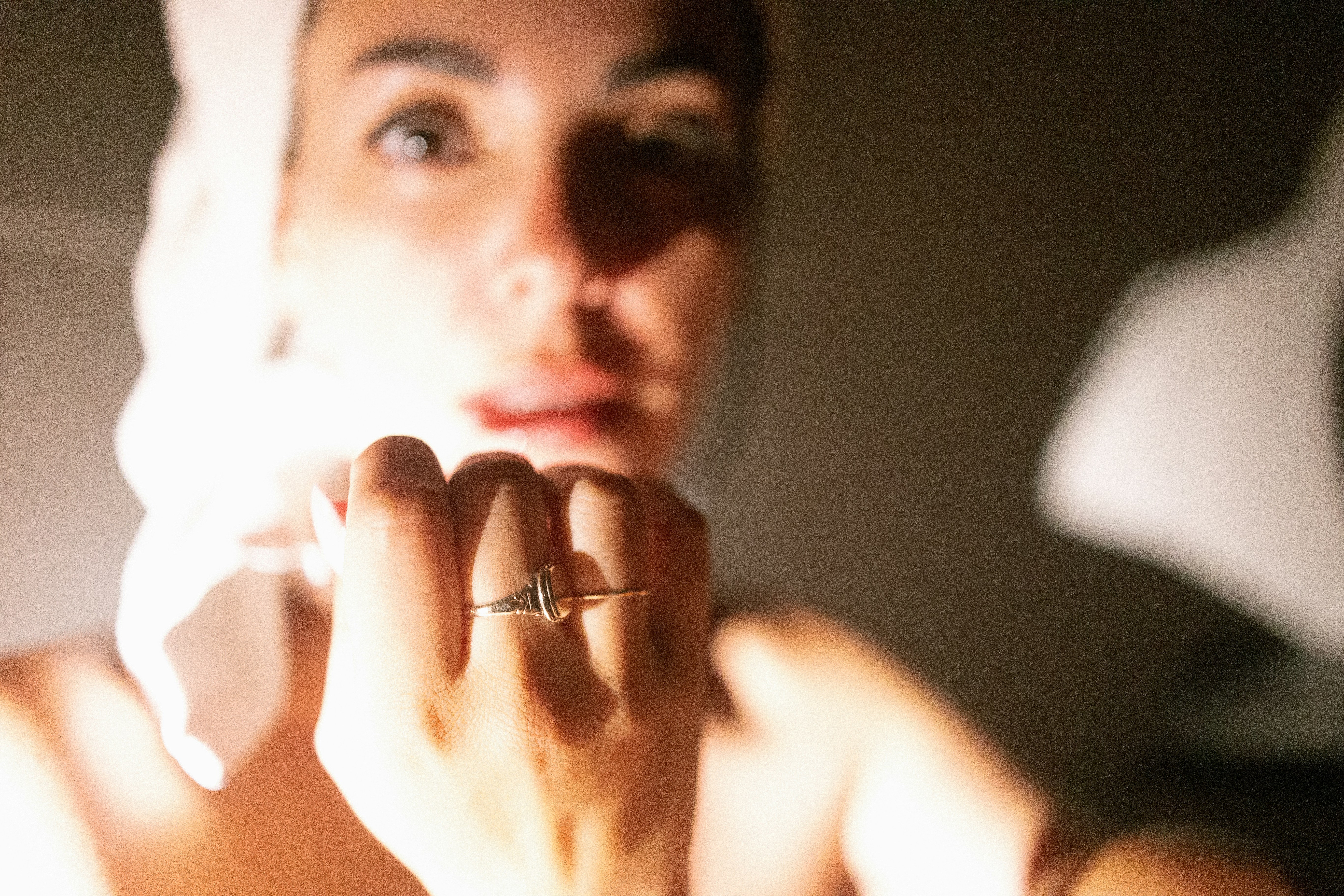 A woman is looking at her reflection in the mirror