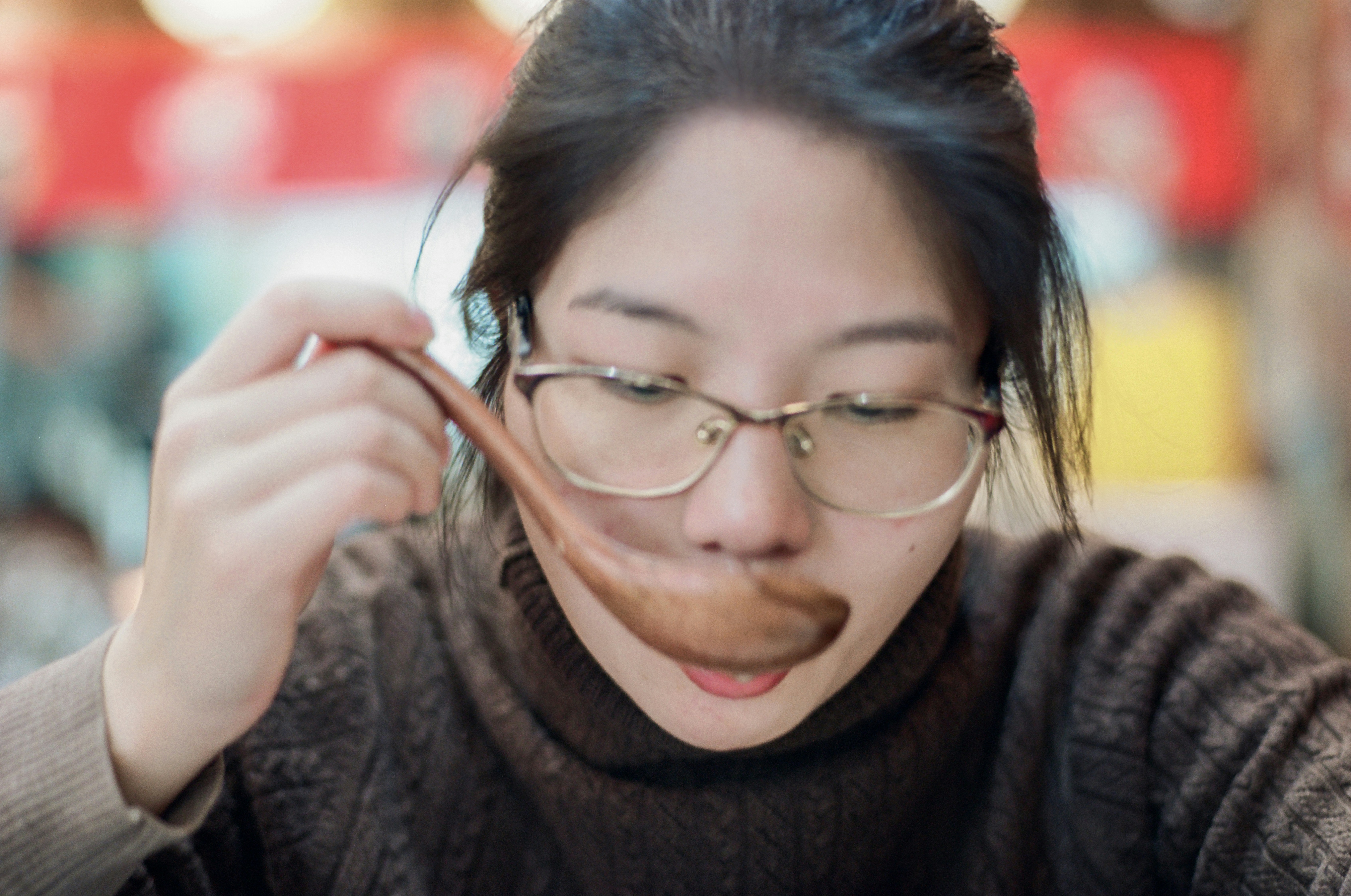 A woman wearing glasses looking at a cell phone