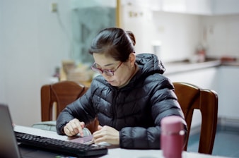 A woman sitting at a table working on a laptop