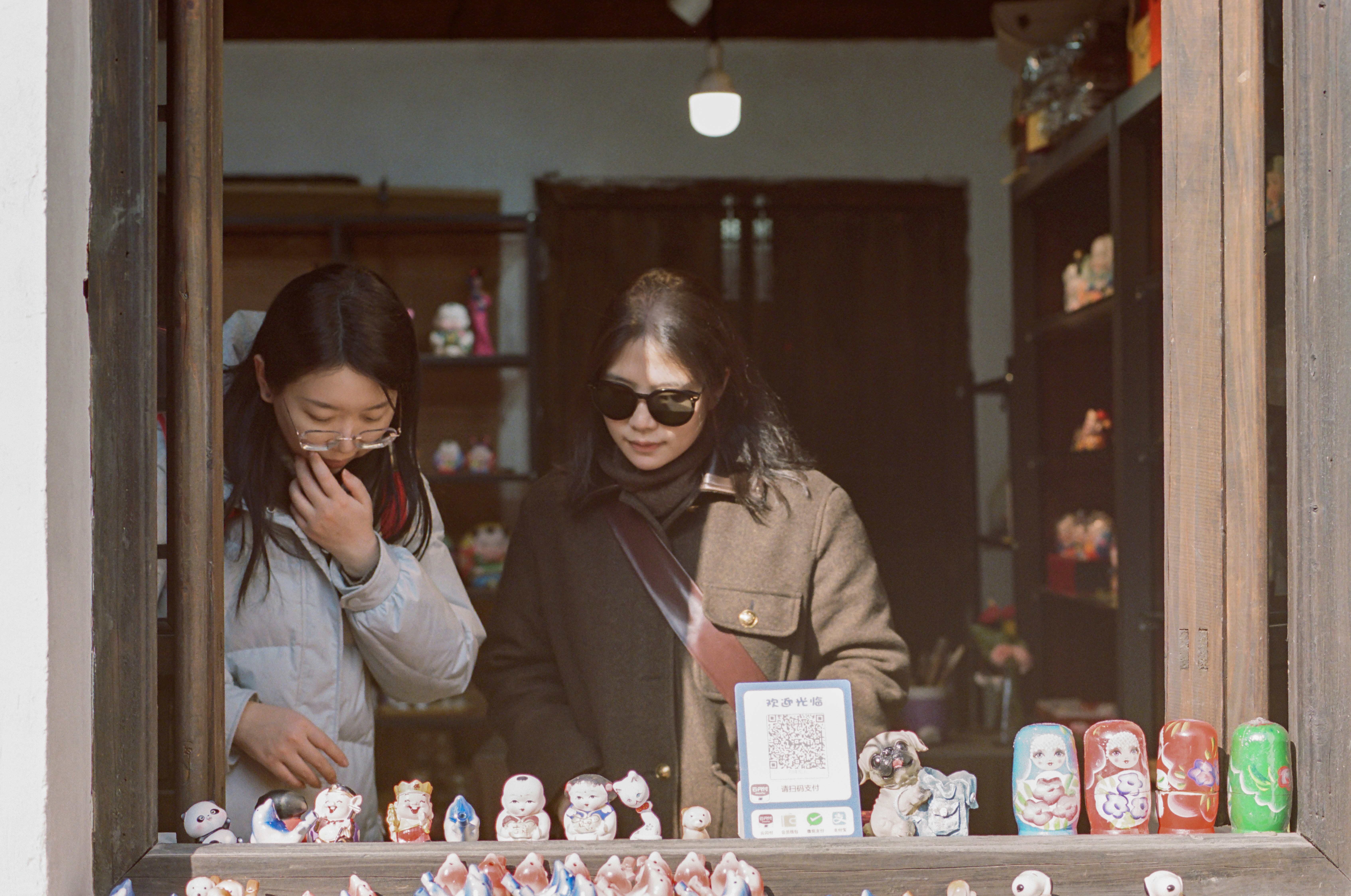A couple of women standing next to each other near a window