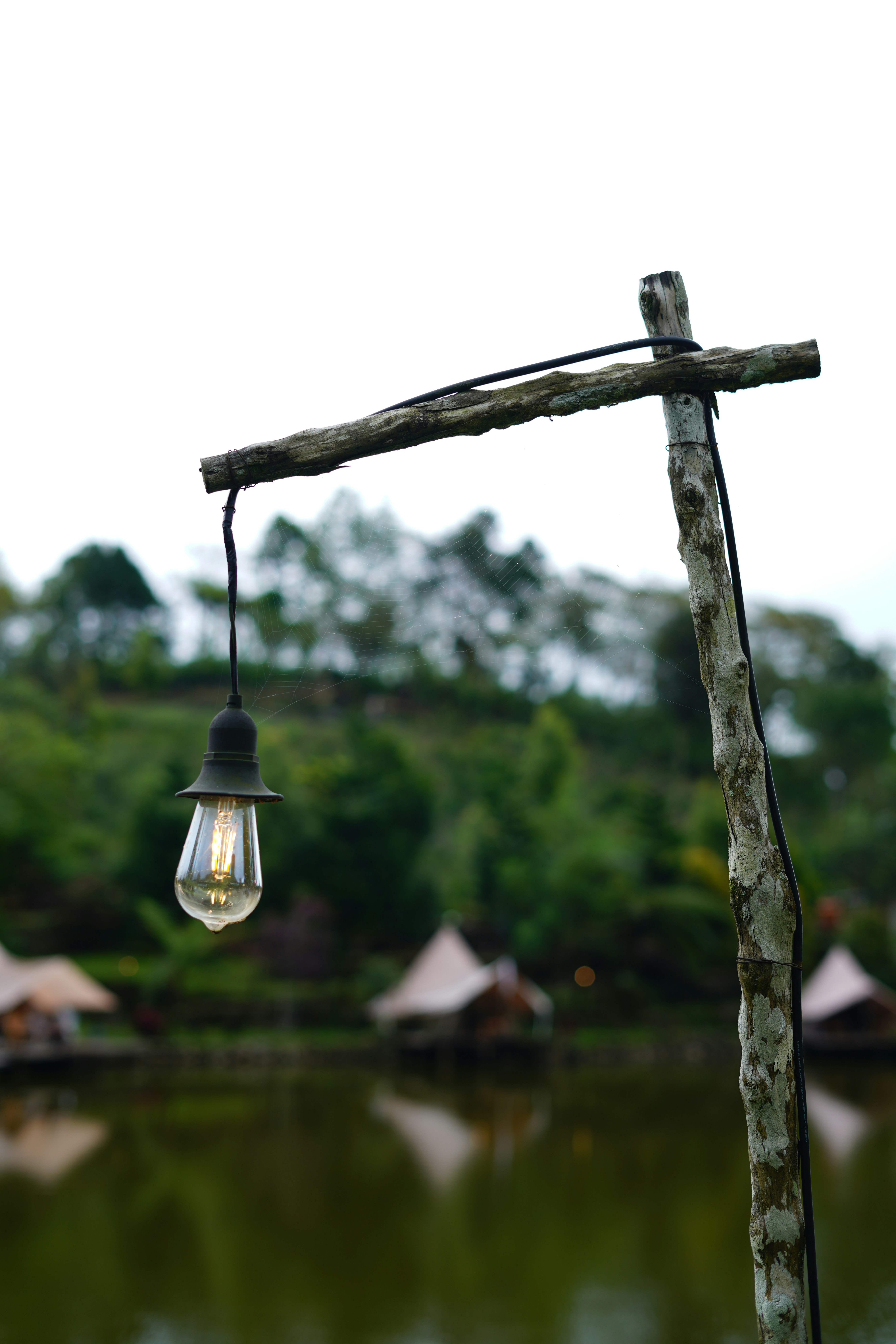 A wooden pole with a light bulb hanging from it