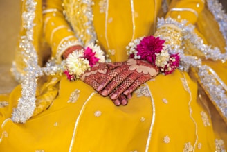 A woman in a yellow dress holding a bouquet of flowers