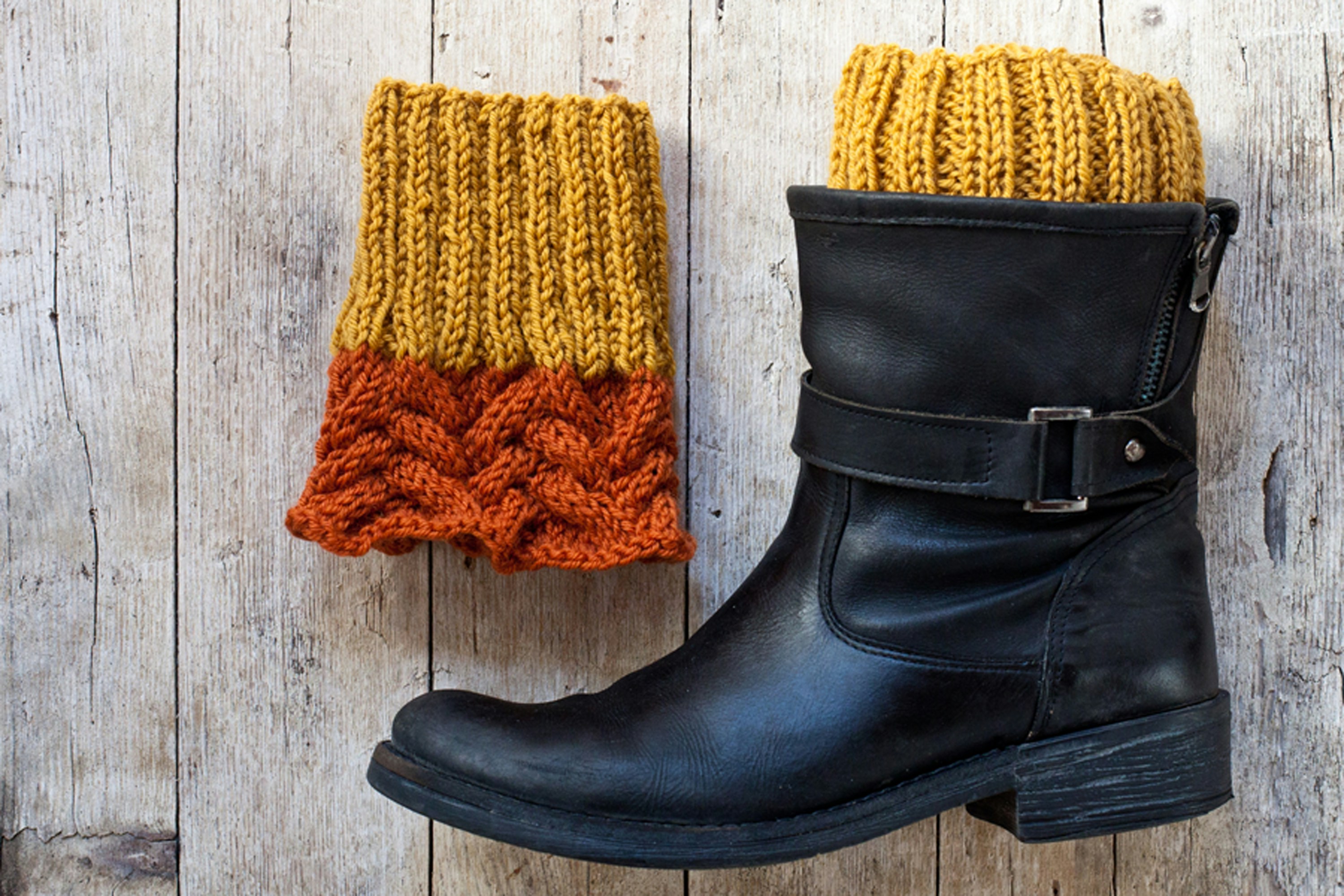 A pair of black boots and a yellow and orange knitted sock