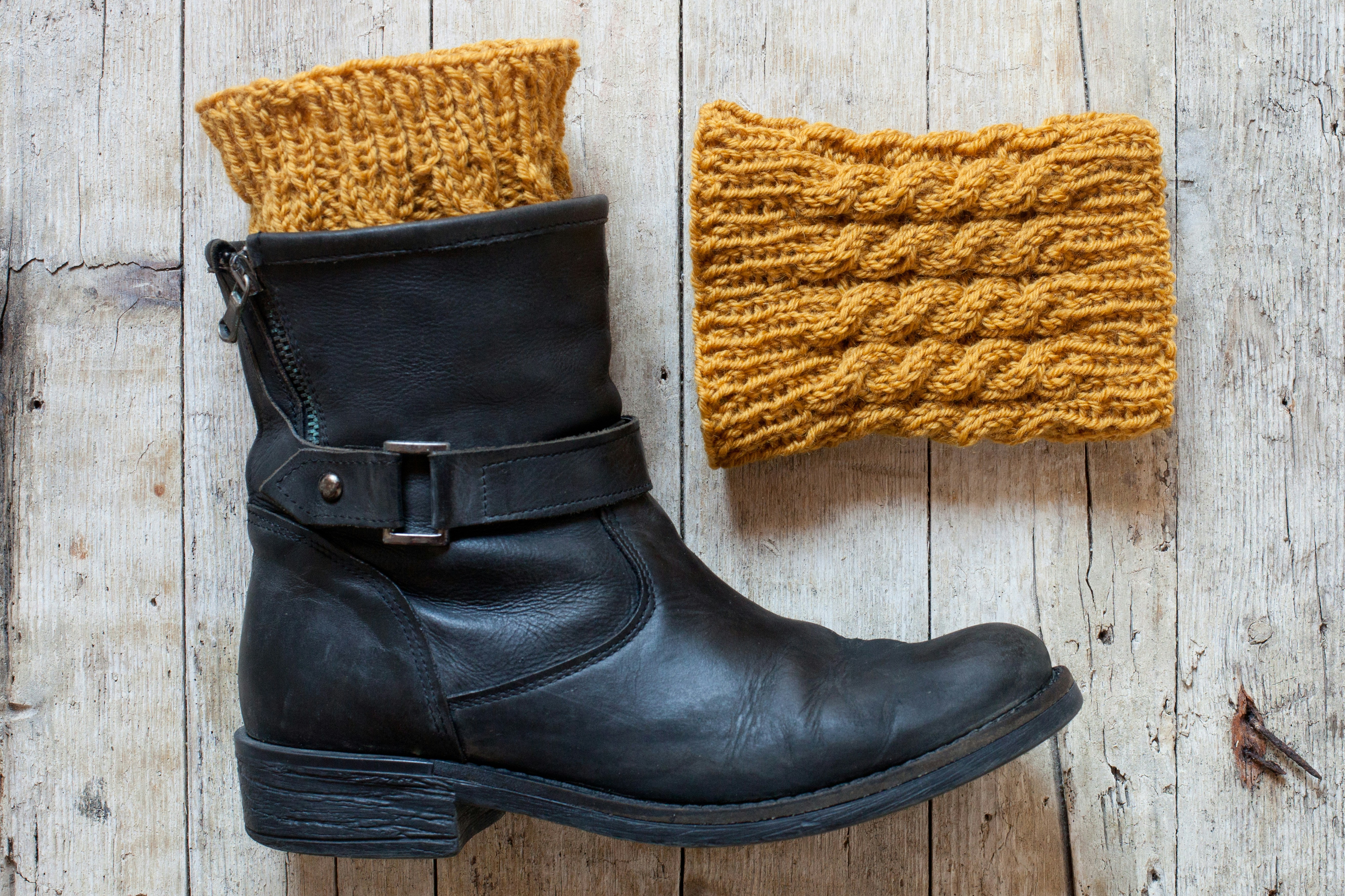 A pair of black boots and a yellow knitted hat