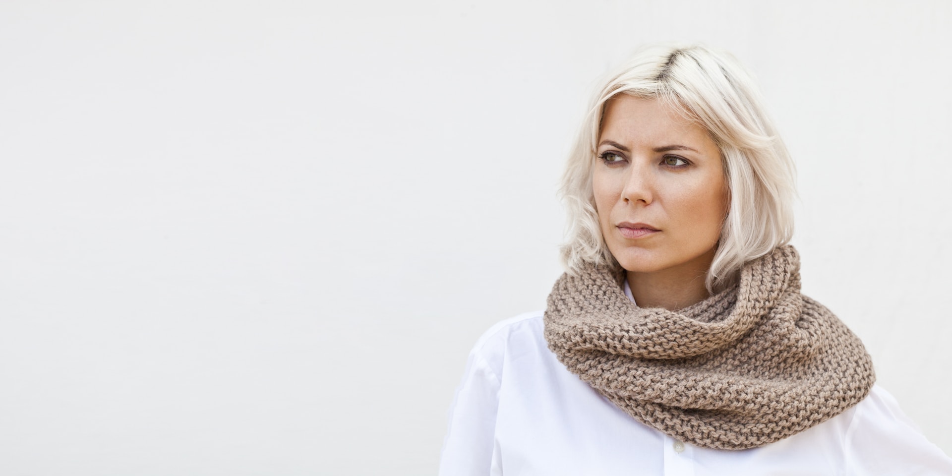 A woman with blonde hair wearing a scarf
