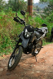 A motorcycle parked on the side of a dirt road