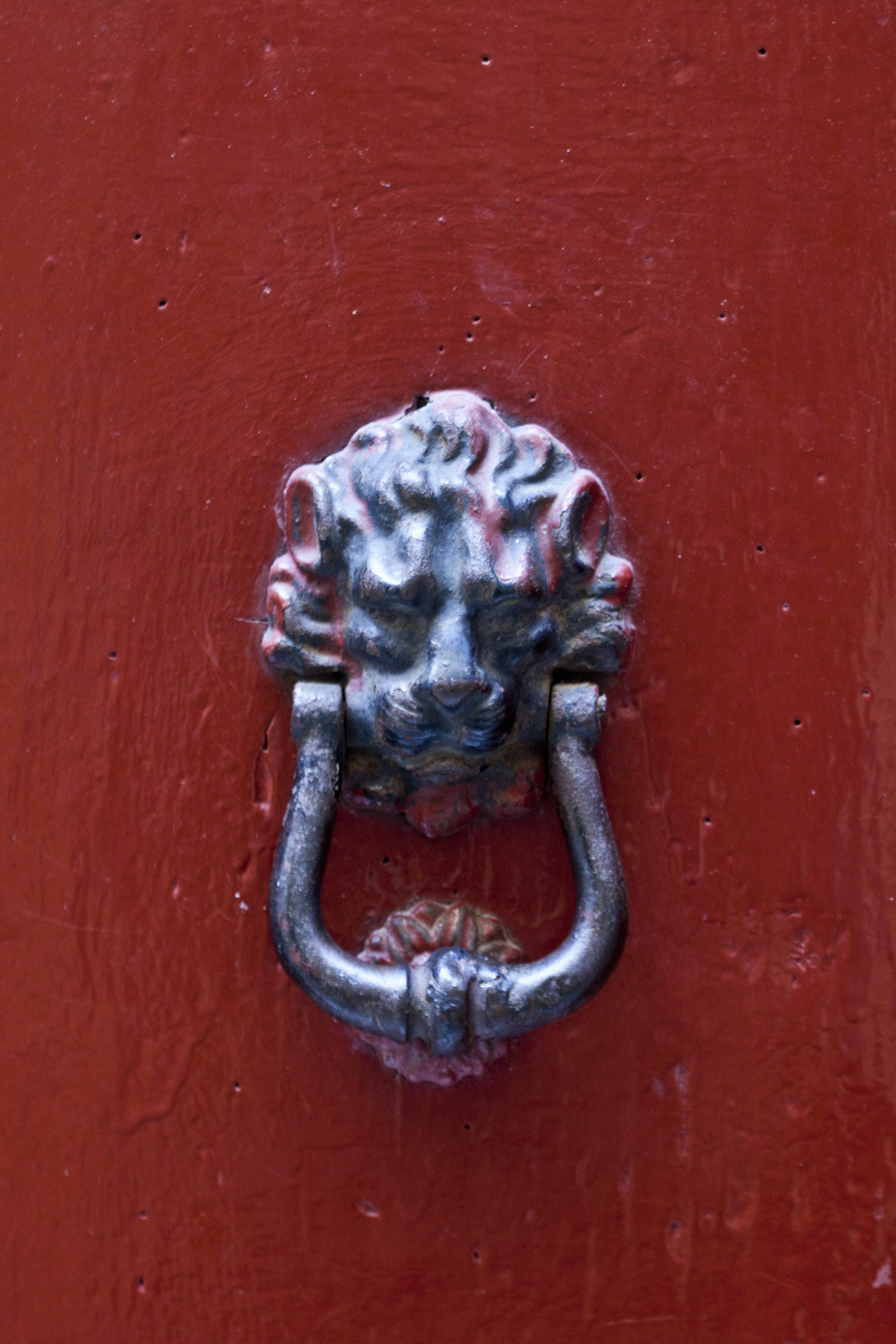 A red door with a lion head handle