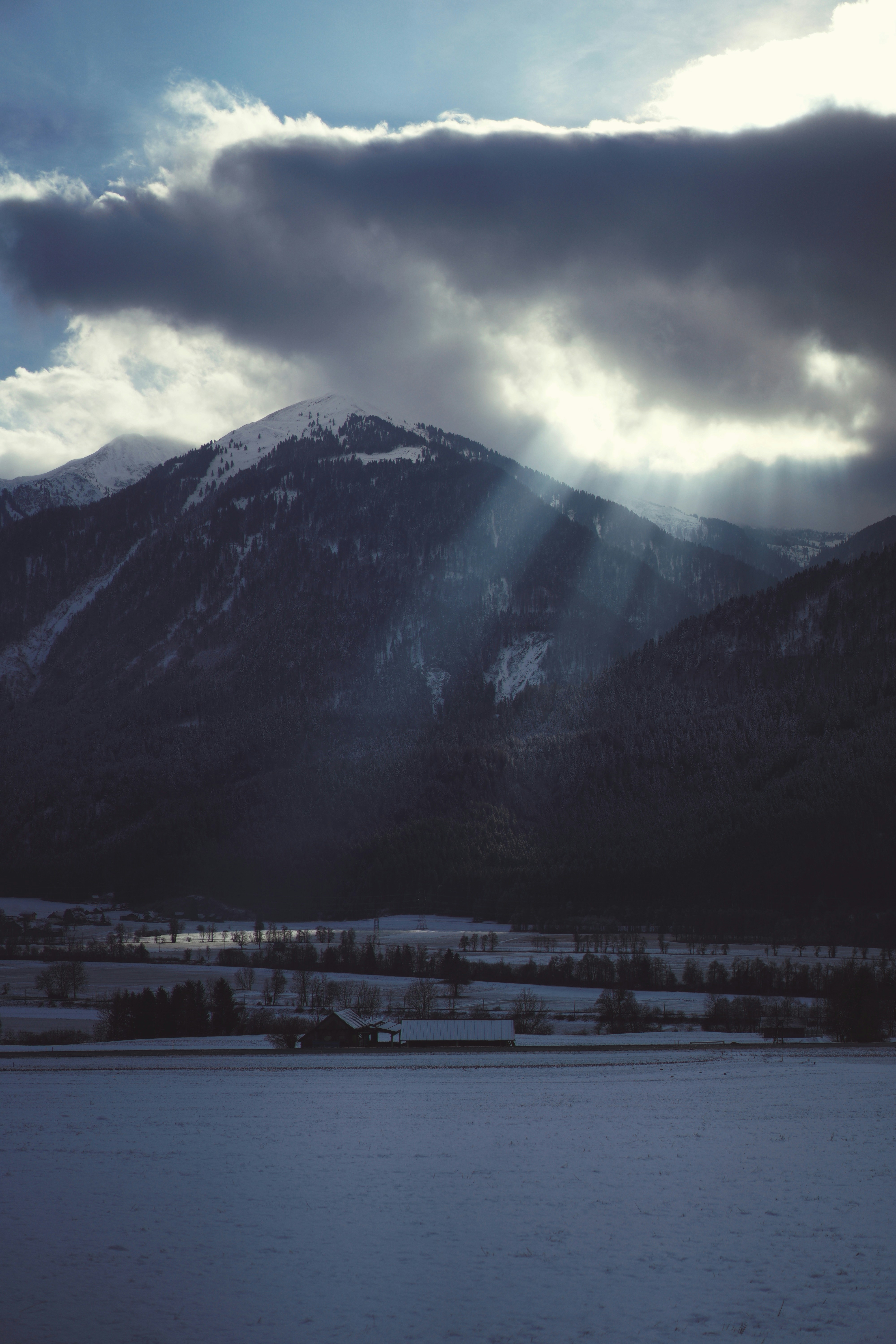 The sun is shining through the clouds over the mountains
