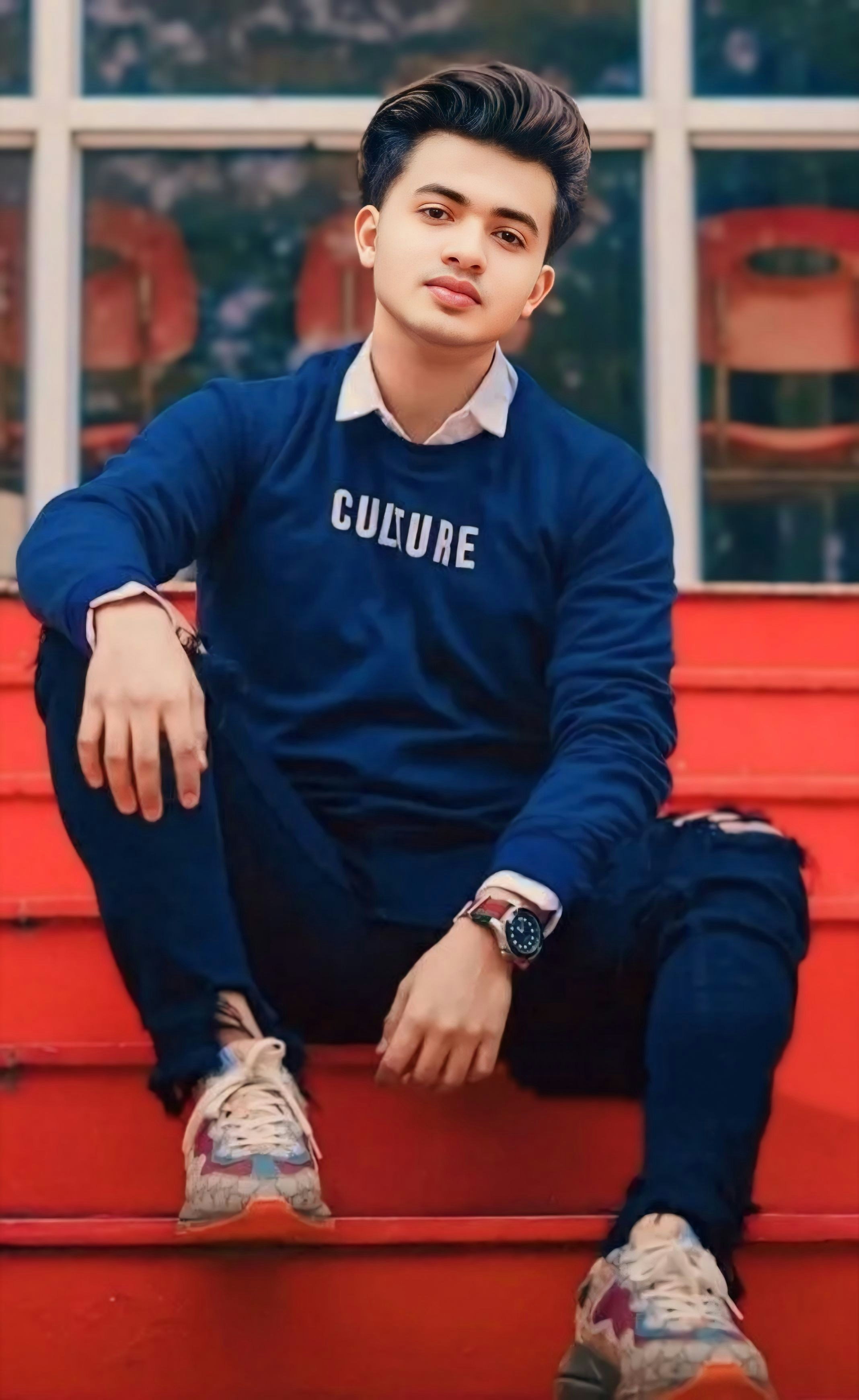 赤い階段の上に座っている若い男性