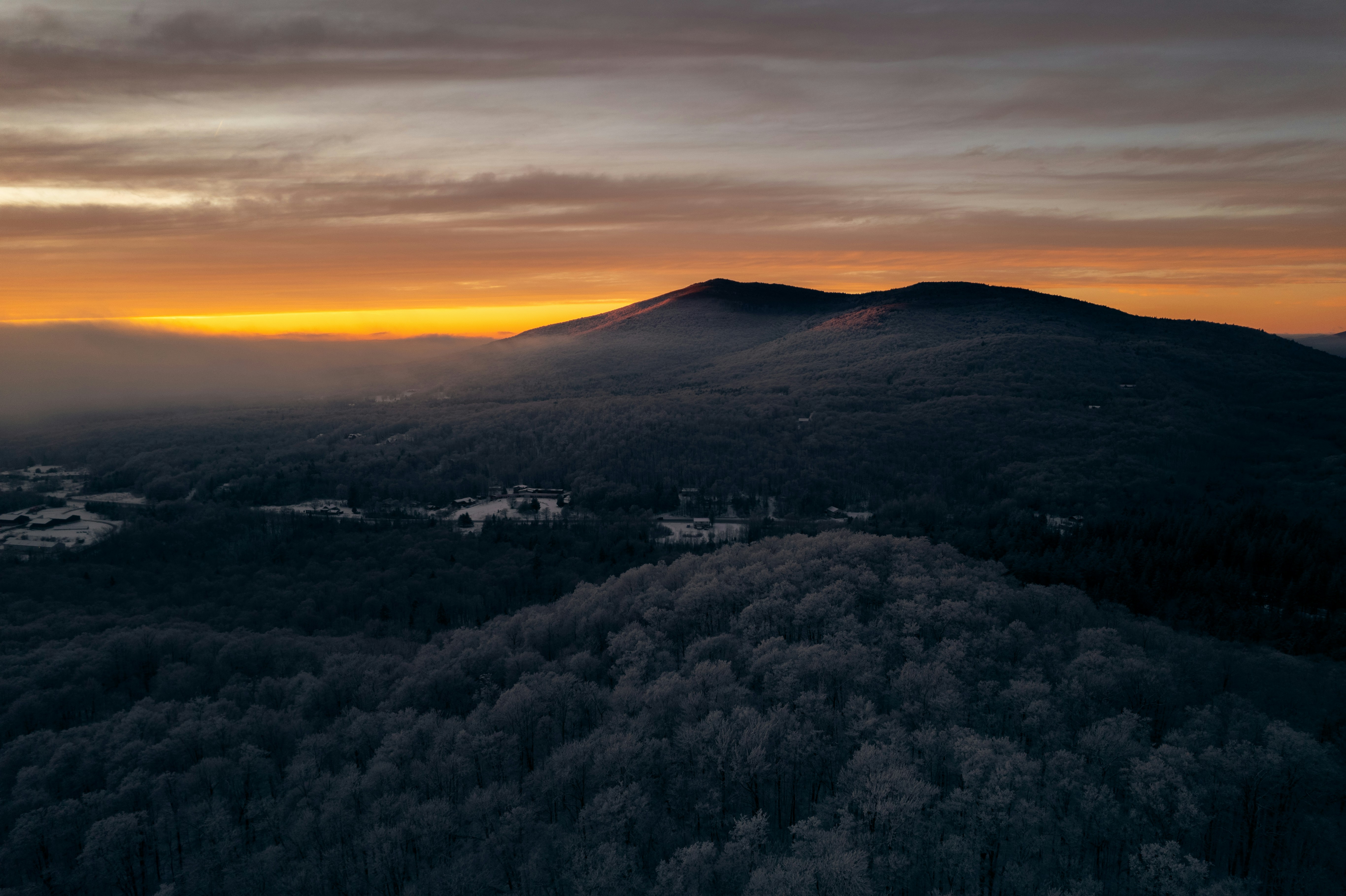 Una vista de una montaña con una puesta de sol al fondo