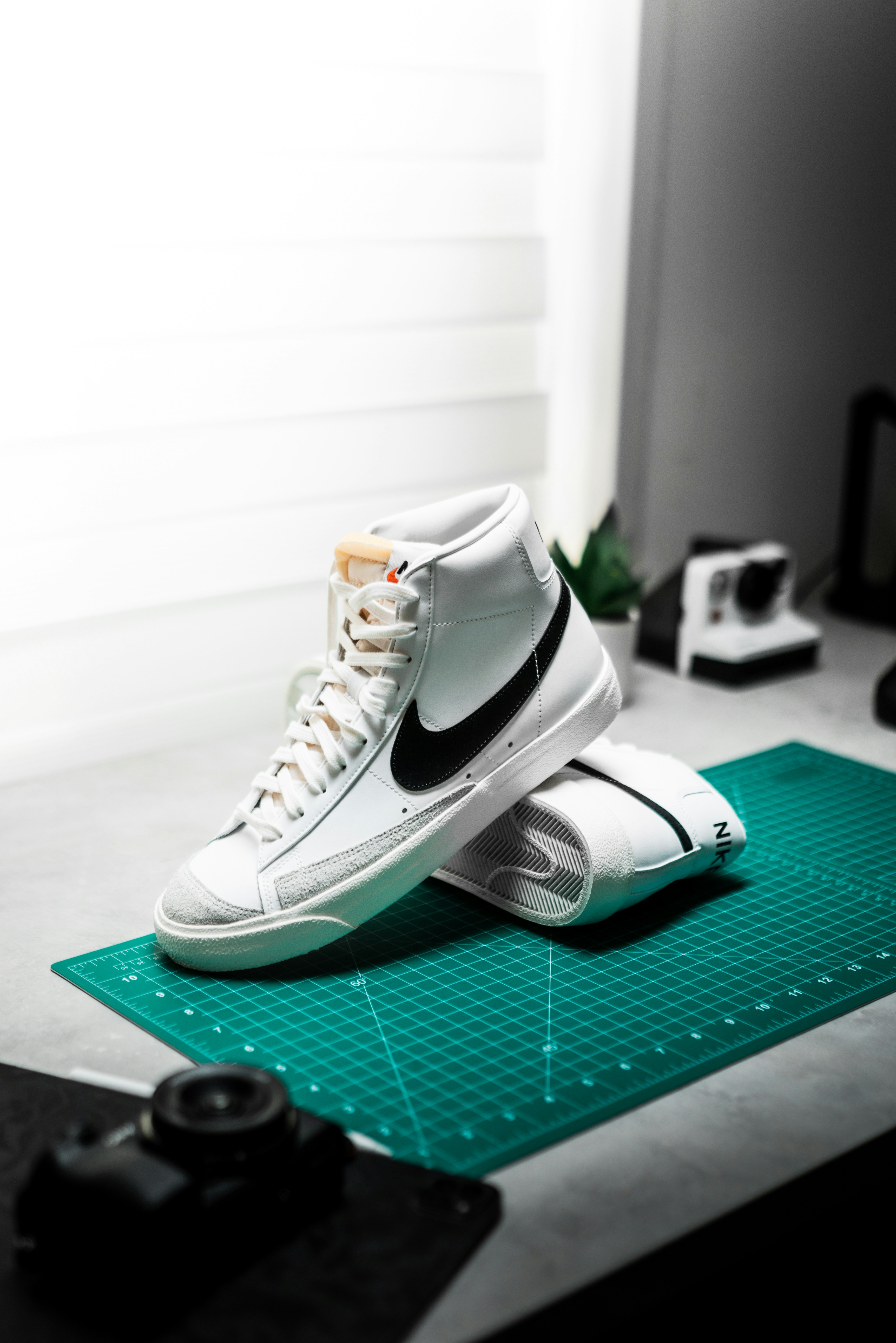 A pair of white sneakers sitting on top of a green mat