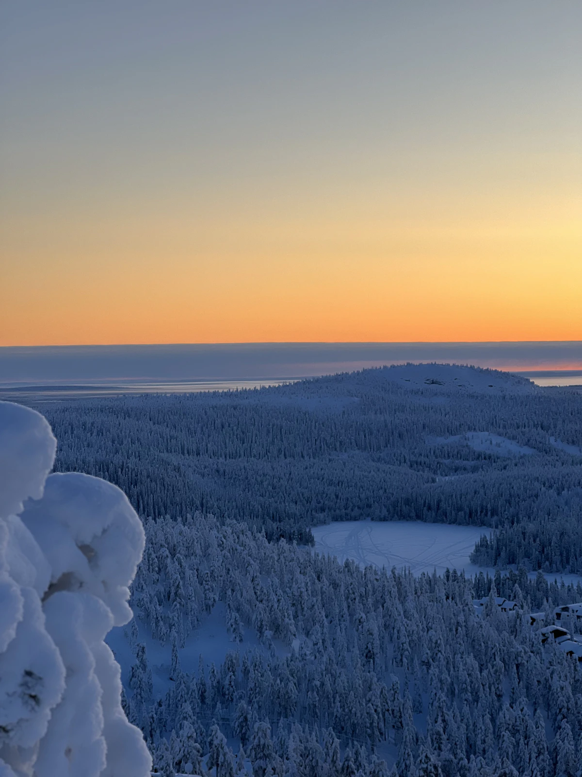 The sun setting over a snowy landscape in Finnish Lapland