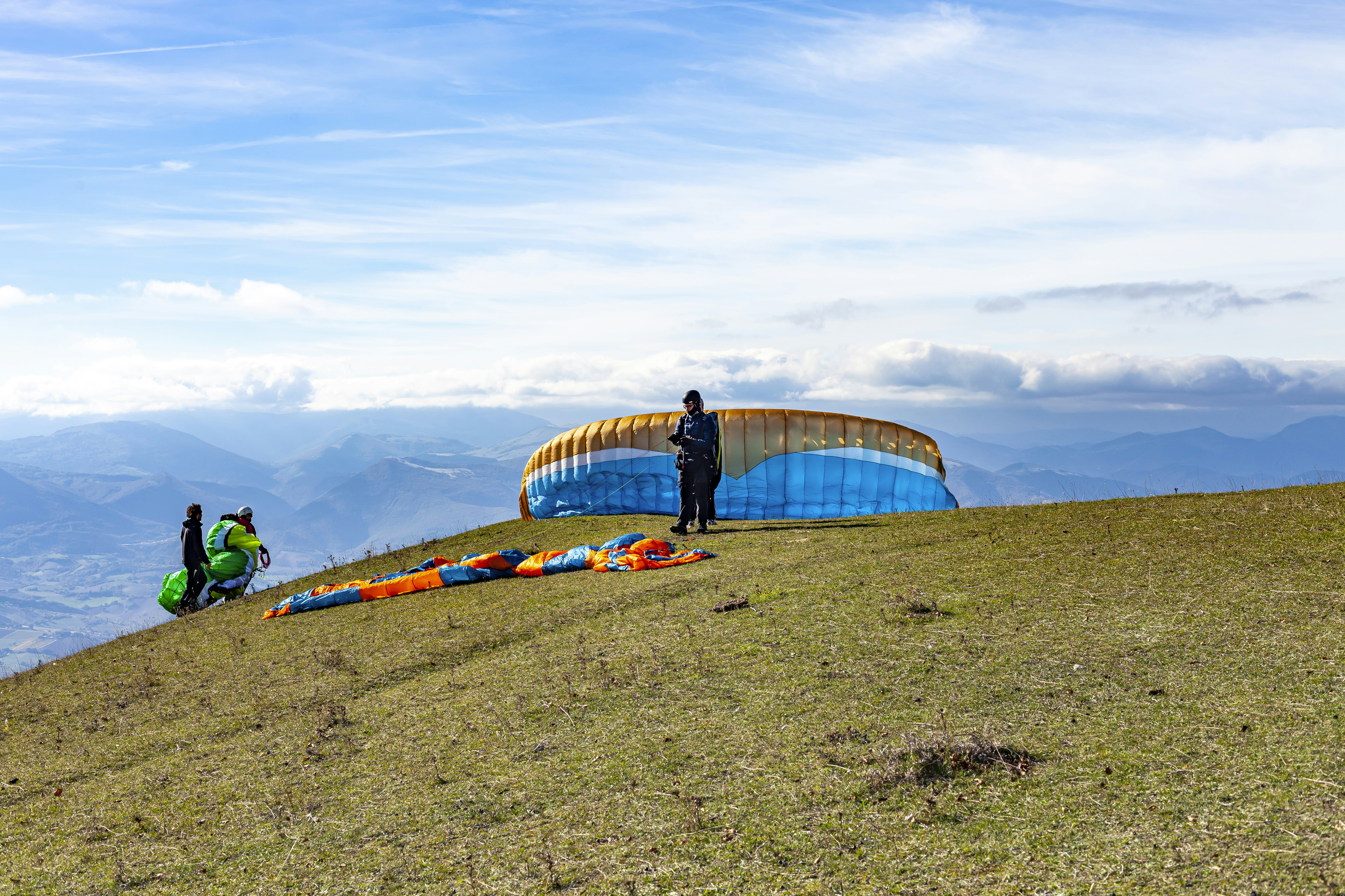 A man standing on top of a grass covered hill