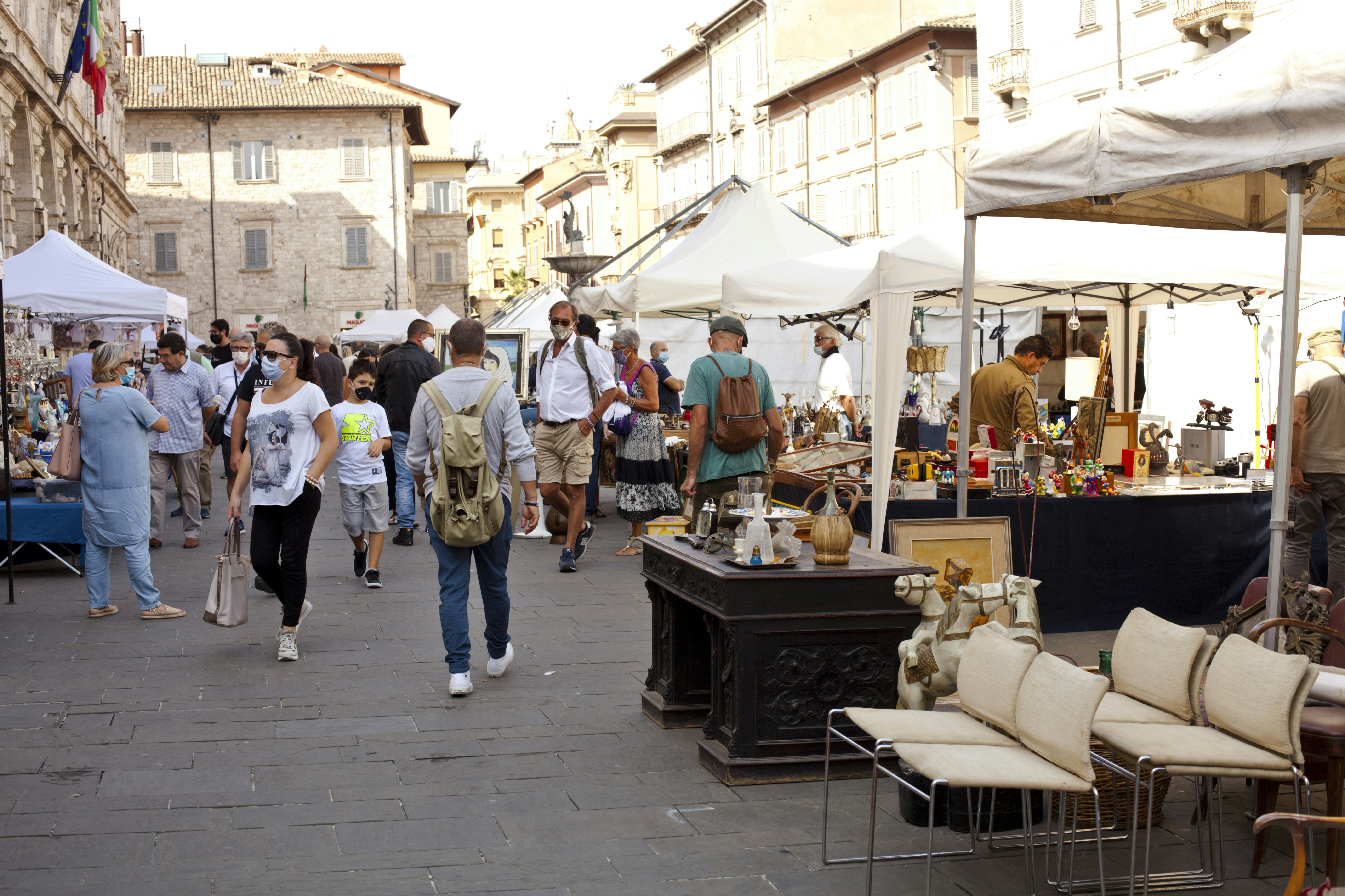 A group of people walking down a street next to tents