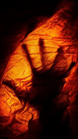 A shadow of a hand on a rock